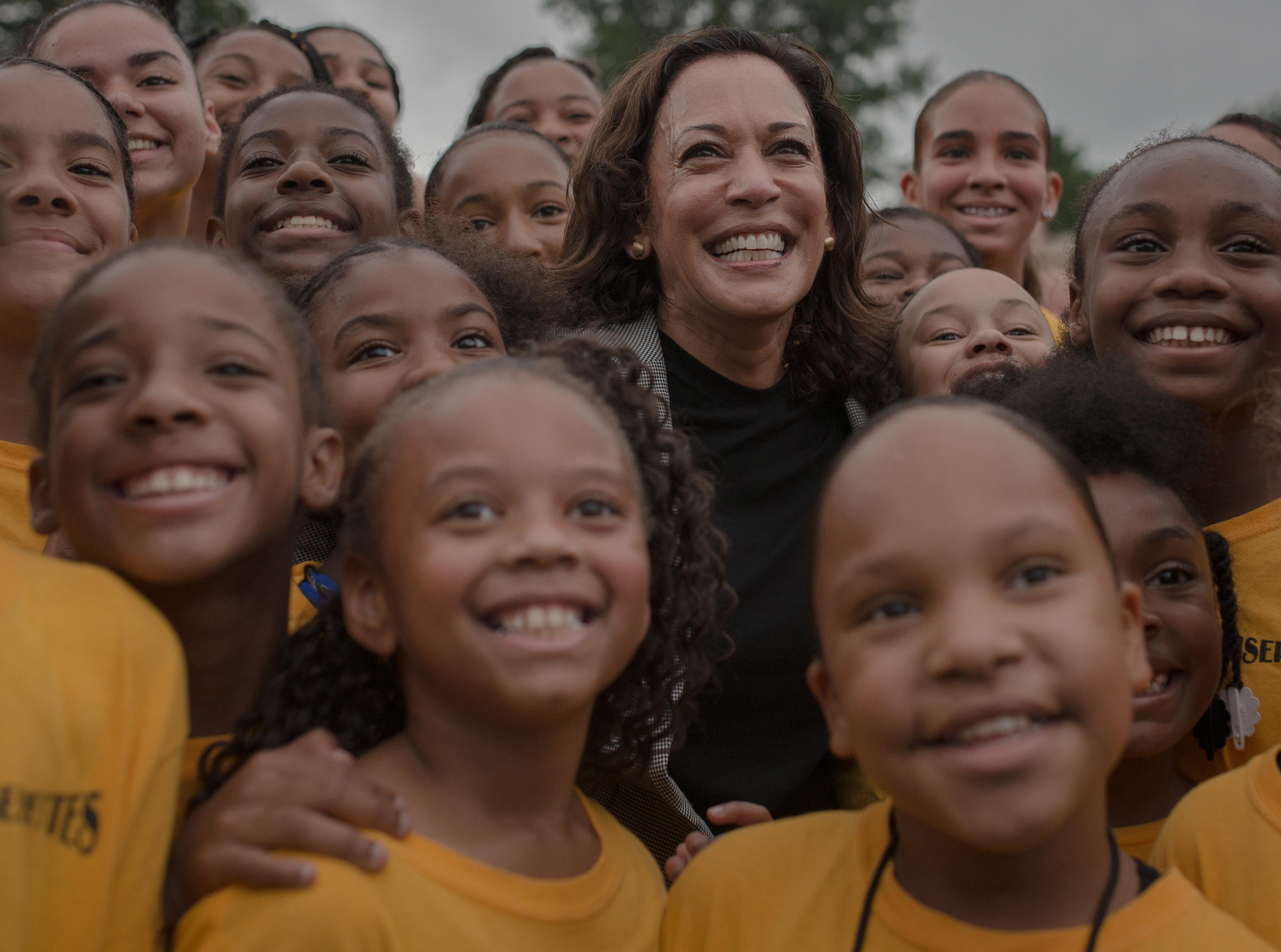 Harris takes takes a photo with the Isiserettes Drill and Drum Corps at a Des Moines Steakfry on Sept. 21, 2019.