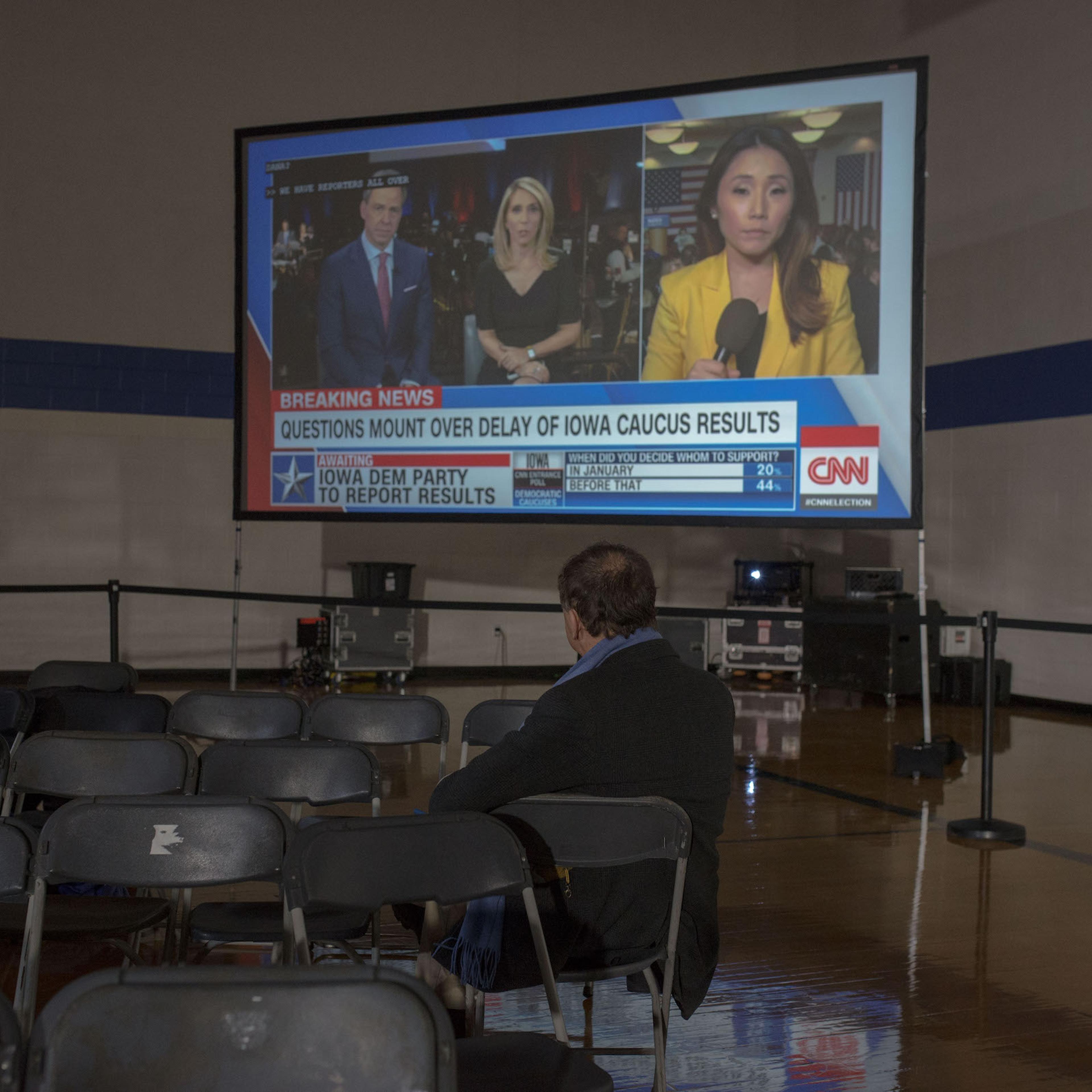 An attendee at an Iowa Caucus watches the news on Caucus Day in Des Moines, Iowa on Feb. 3, 2020.