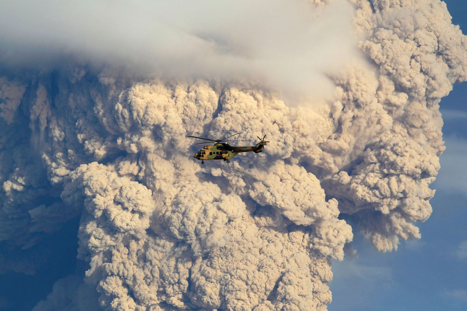 A helicopter flies over smoke and ash rising from the Puyehue-Cordon Caulle volcanic chain near Osorno city in south-central Chile June 5, 2011.