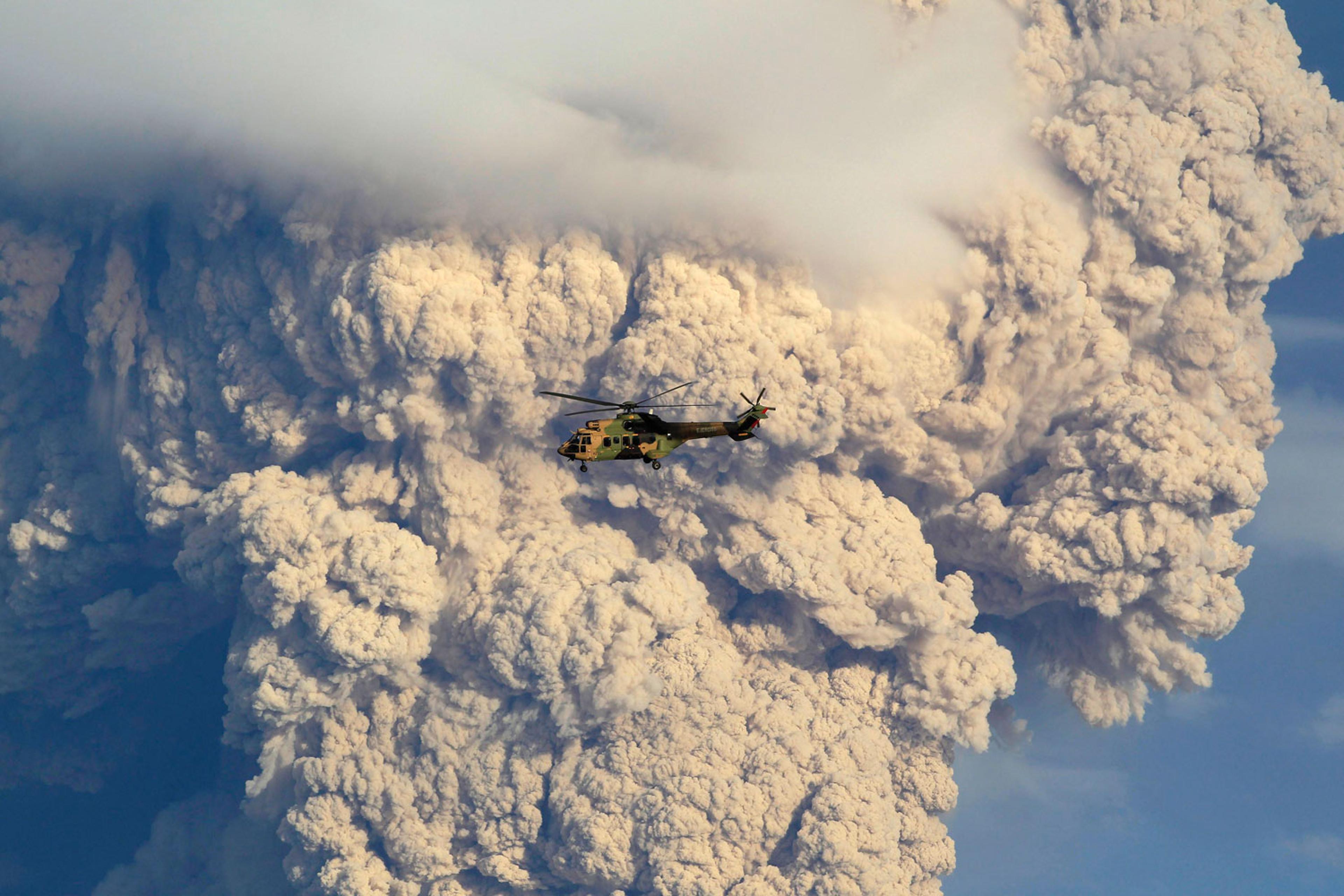 A helicopter flies over smoke and ash rising from the Puyehue-Cordon Caulle volcanic chain near Osorno city in south-central Chile June 5, 2011.
