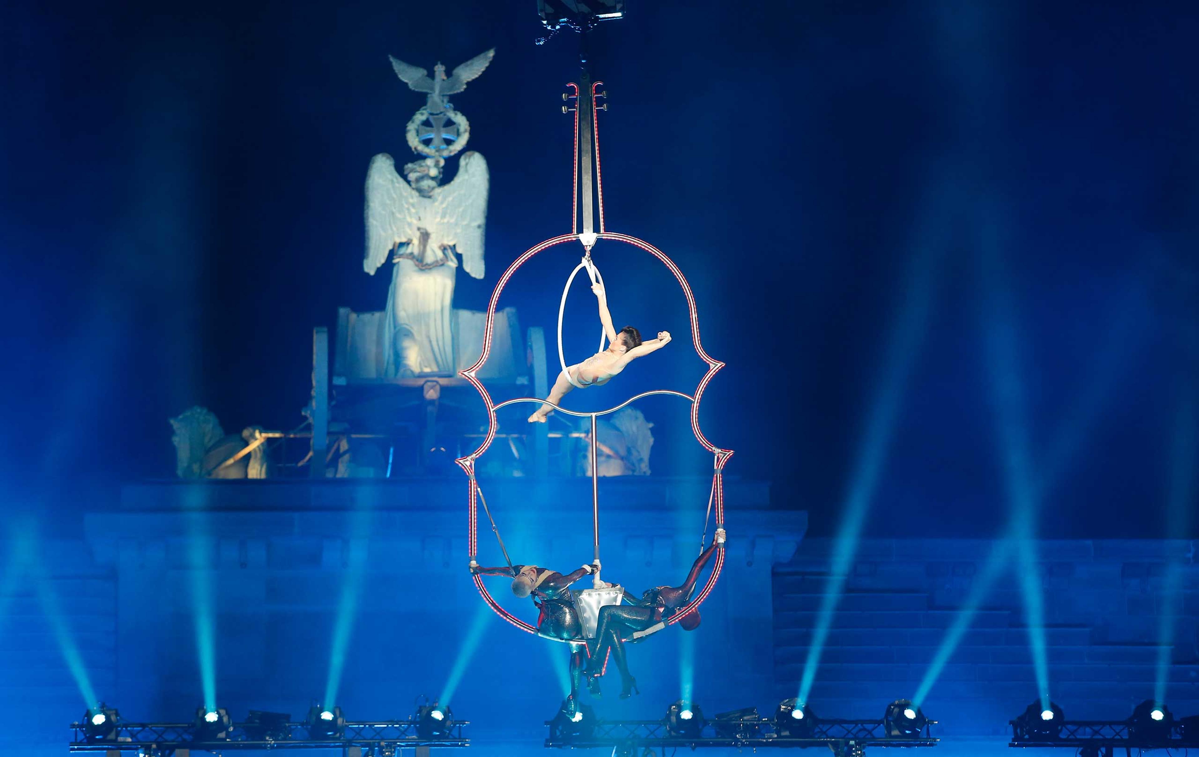 An acrobatic artist performs in front of the Quadriga on top of the Brandenburg Gate in Berlin
