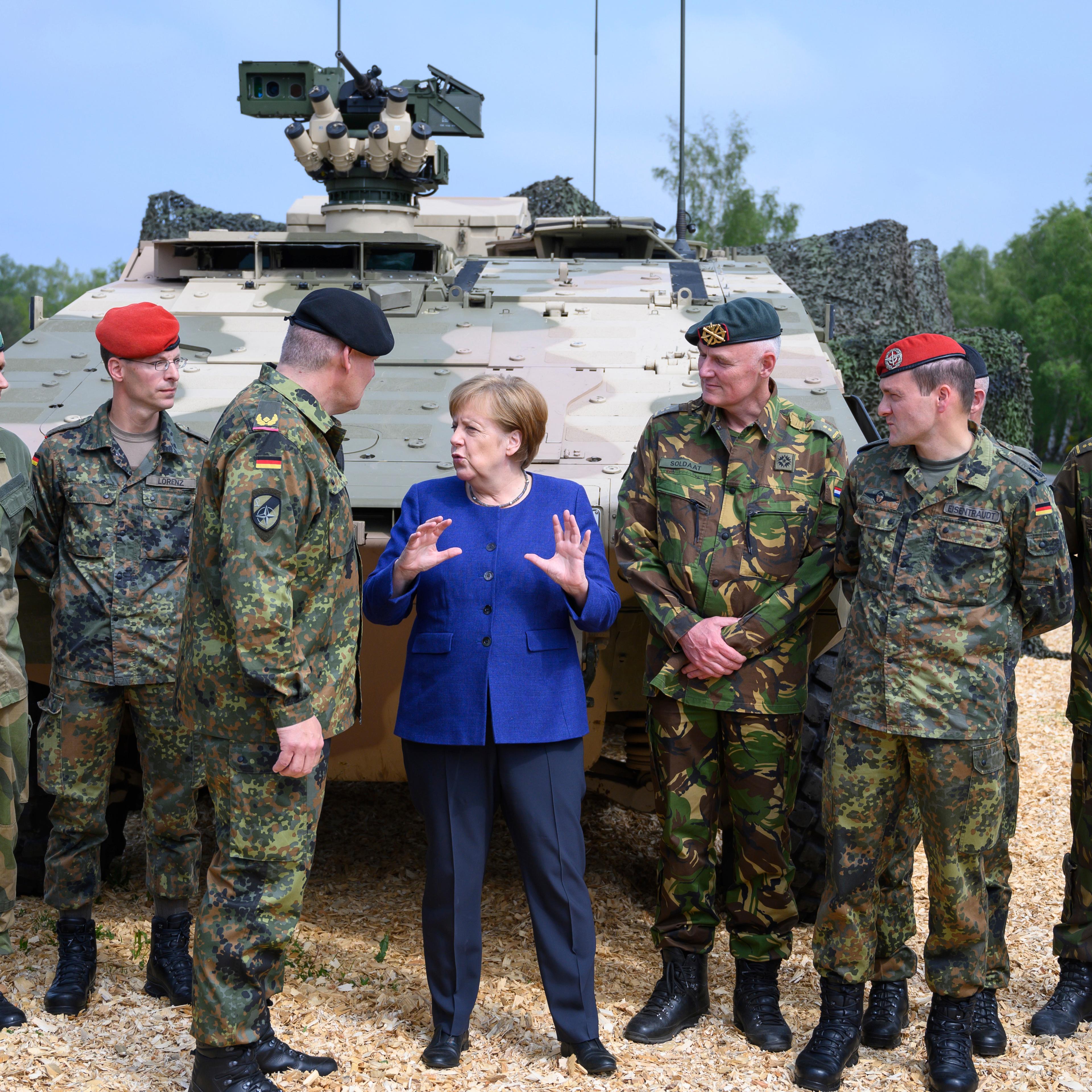 Germany’s military is investigating what information three Chinese reporters collected while Chancellor Angela Merkel visited a NATO base.