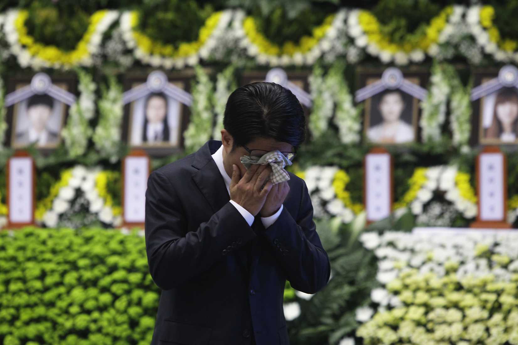 A man weeps after tribute at a group memorial altar for victims of sunken passengers ship at the Ansan Olympic Memorial Hall on April 23, 2014 in Ansan, South Korea.