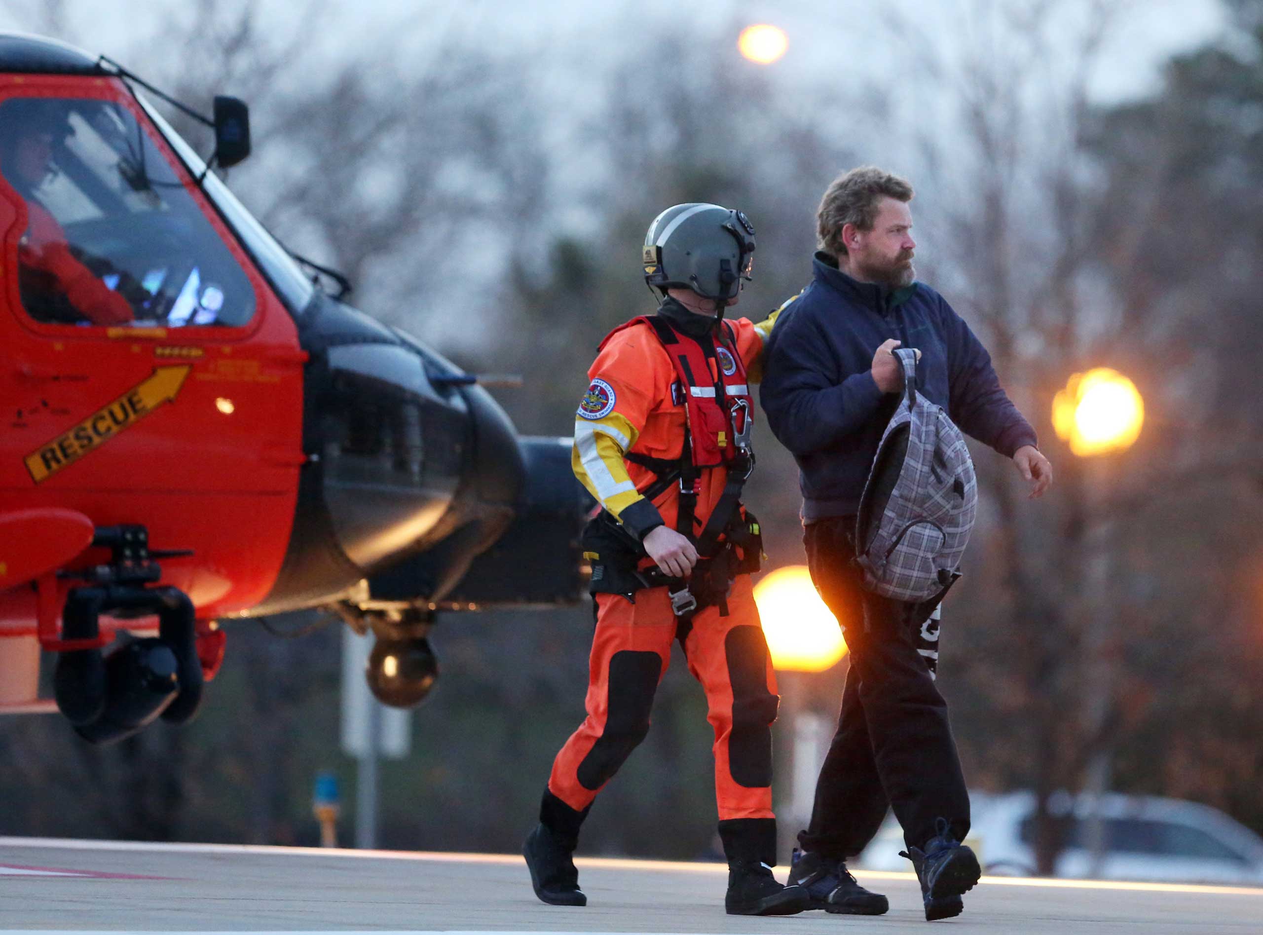 Louis Jordan, right, walks from the Coast Guard helicopter to the Sentara Norfolk General Hospital in Norfolk, Va., on Thursday, April 2, 2015.