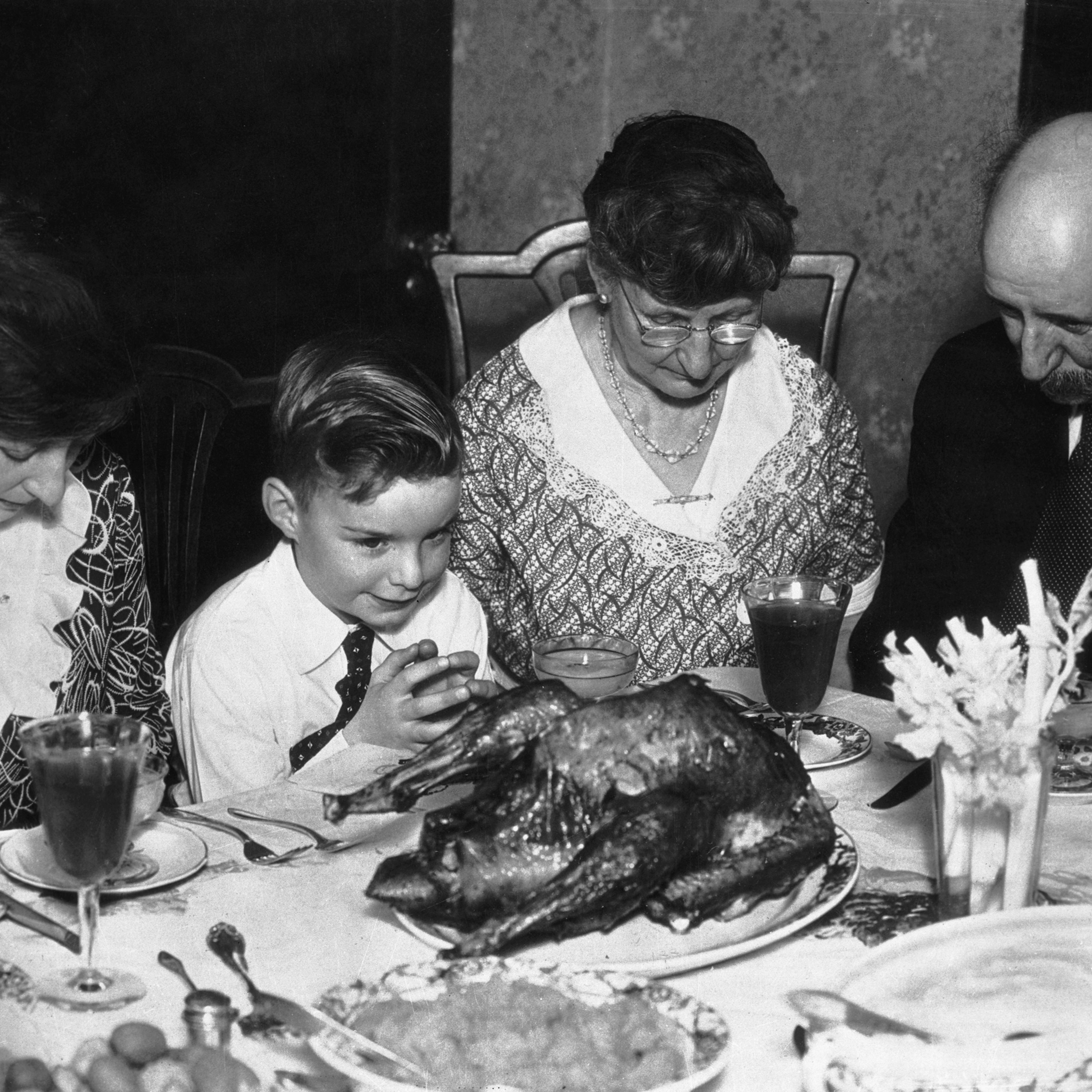 Family Saying Grace Before Thanksgiving Dinner