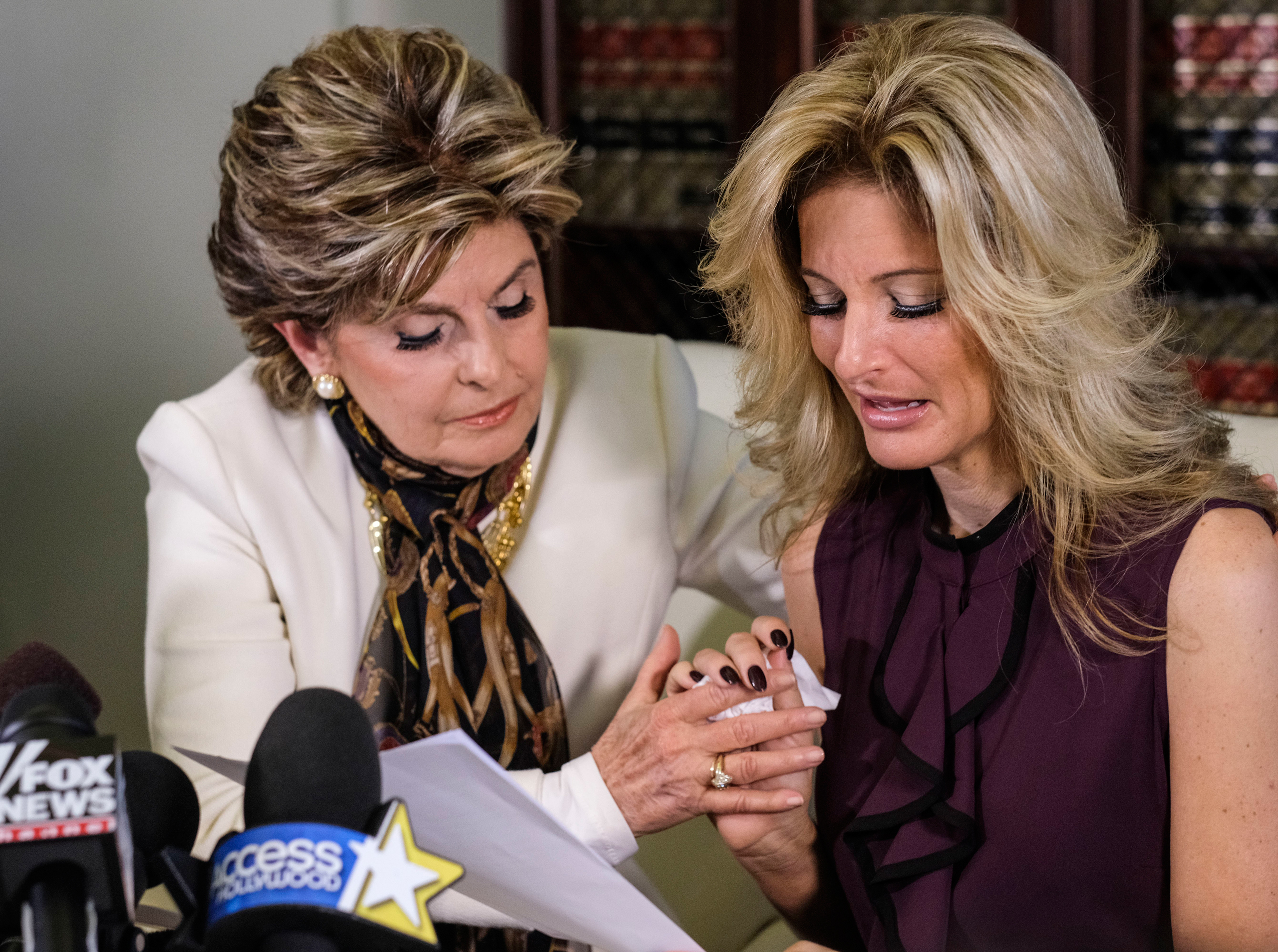 Attorney Gloria Allred, left, comforts Summer Zervos as Zervos reads a statement during a news conference in Los Angeles, Friday Oct. 14, 2016. Zervos, a former contestant on "The Apprentice" says Republican presidential candidate Donald Trump made unwan