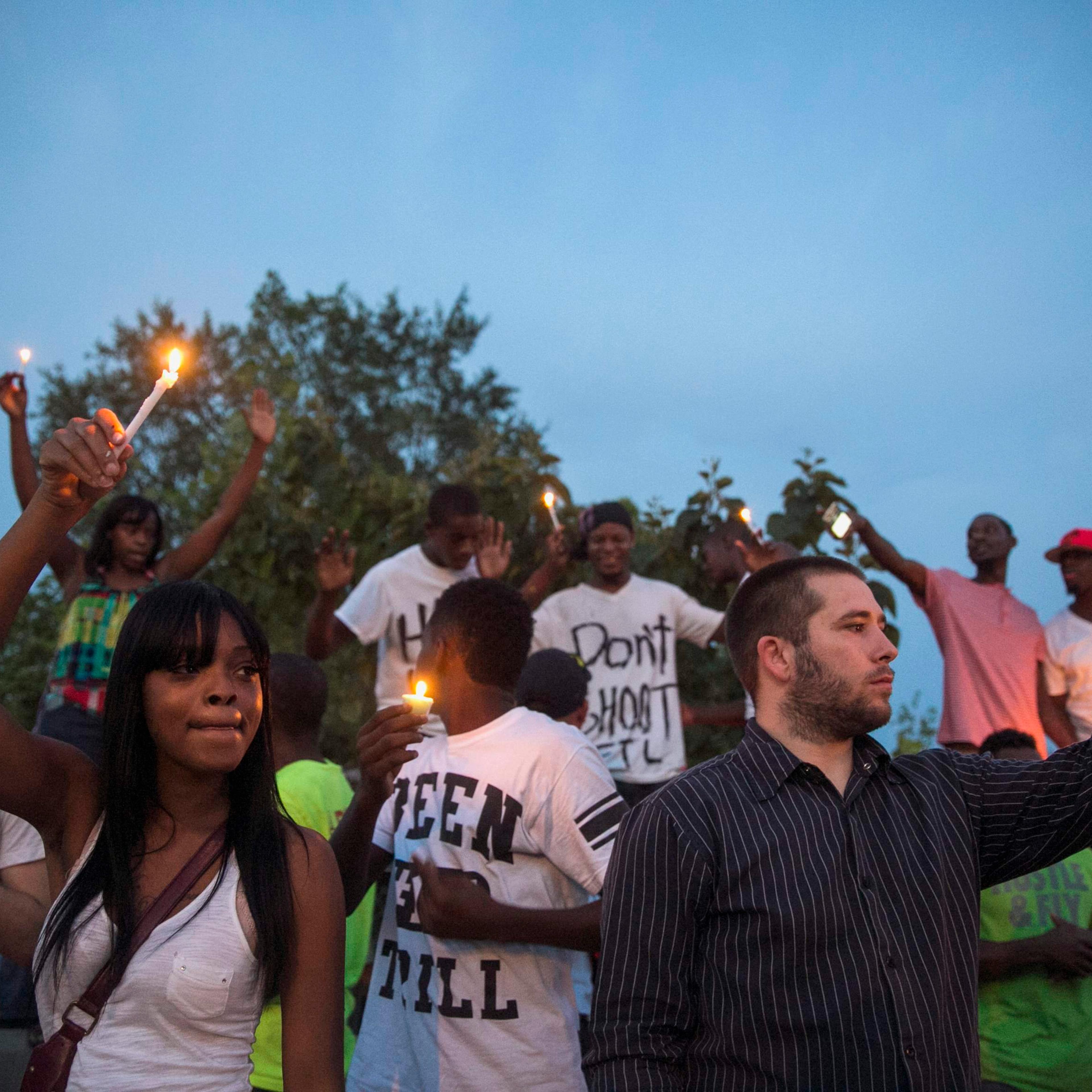 Protesters light candles as they take part in a peaceful demonstration, as communities react to the shooting of Michael Brown in Ferguson, Missouri August 14, 2014.