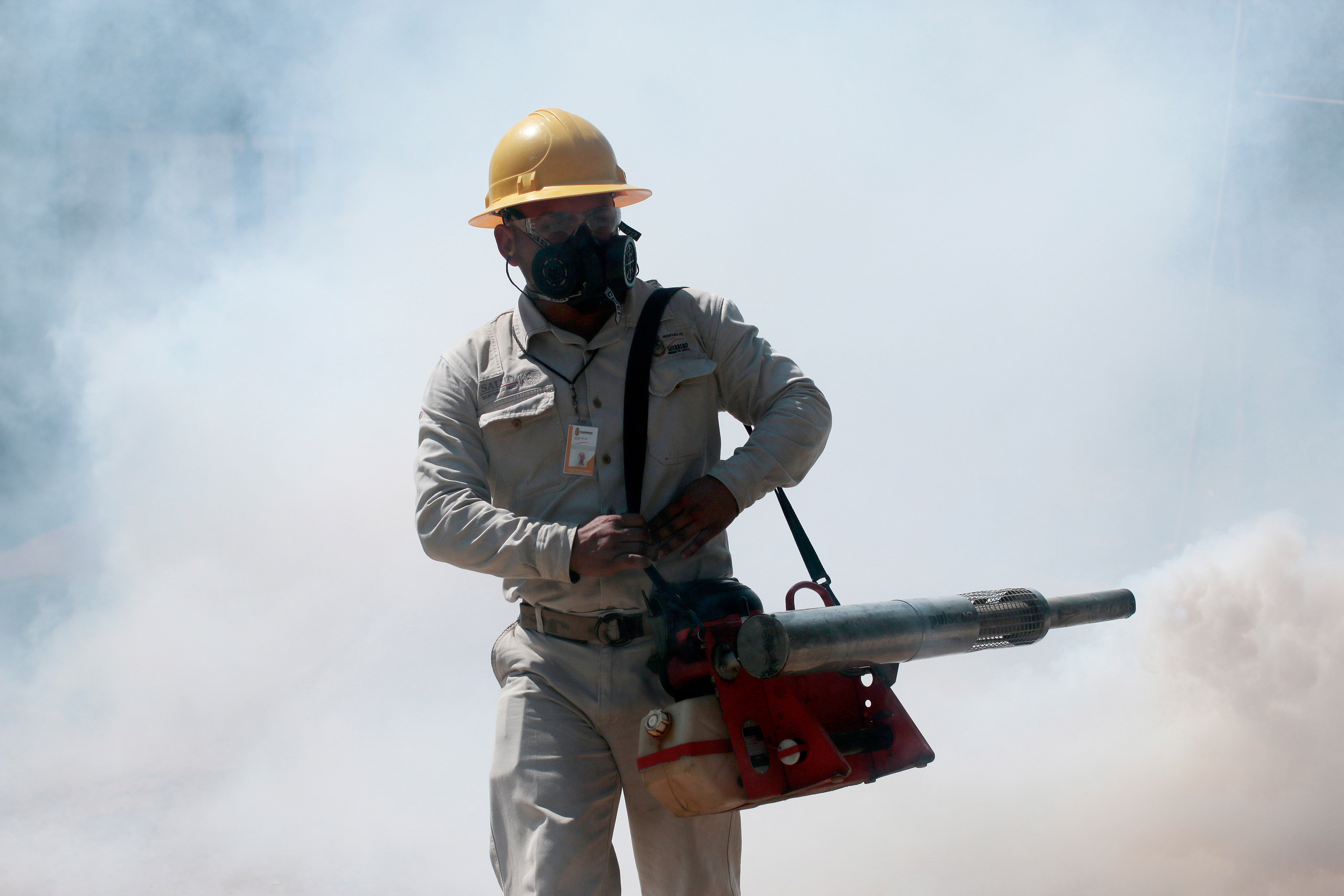 An employee of the Health Secretariat fumigates against the Aedes aegypti mosquito to prevent the spread of the Zika, Chikungunya and Dengue in Acapulco, Guerrero State, Mexico on February 2, 2016. AFP PHOTO/ Pedro PARDO / AFP / Pedro PARDO (Photo credit