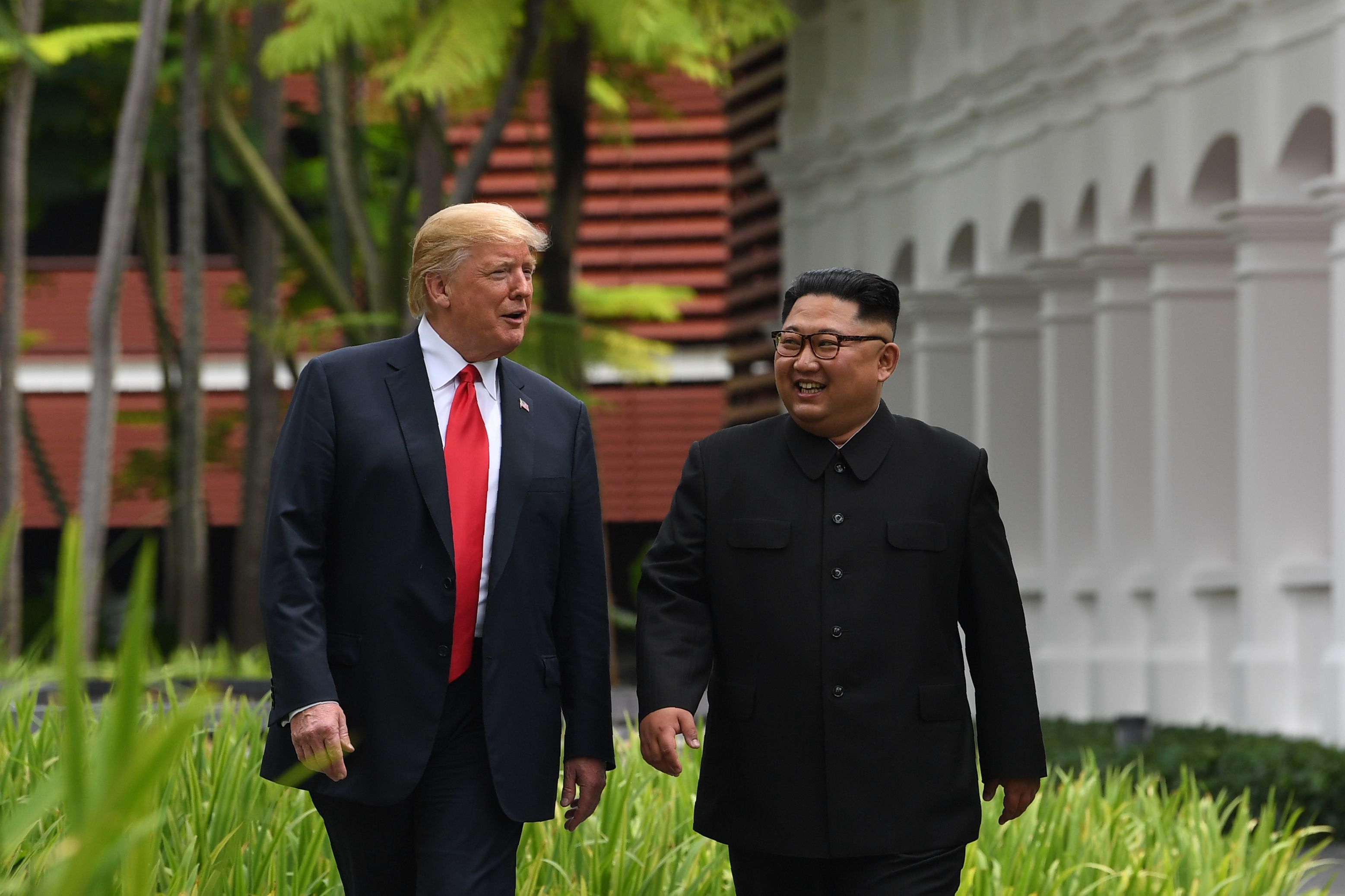 North Korea's leader Kim Jong Un walks with President Donald Trump during a break in talks at their historic US-North Korea summit, at the Capella Hotel on Sentosa island in Singapore