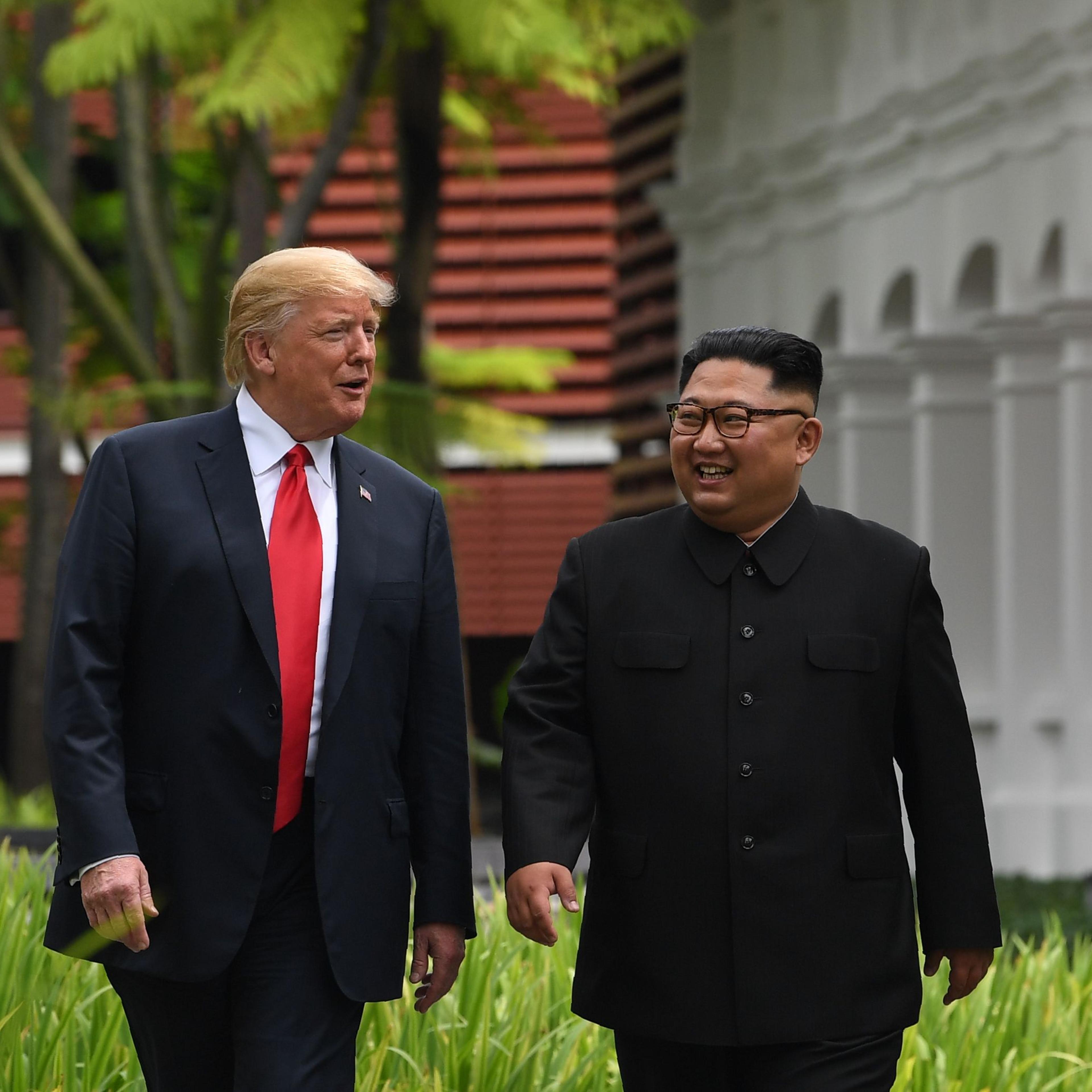 North Korea's leader Kim Jong Un walks with President Donald Trump during a break in talks at their historic US-North Korea summit, at the Capella Hotel on Sentosa island in Singapore