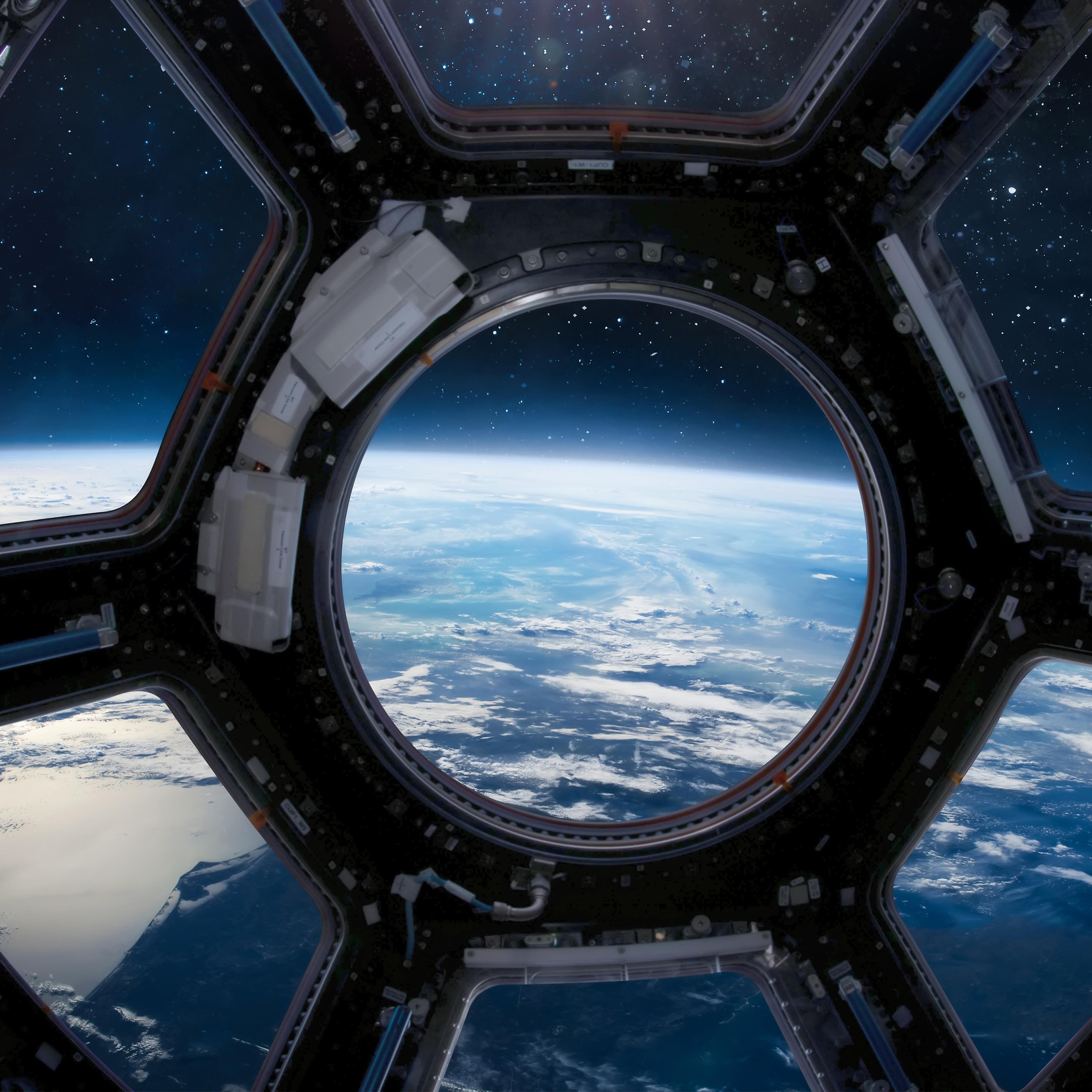 Cupola porthole on ISS orbital station. International space station. Orbit and deep space with stars view from porthole. Spaceship and blue planet. People in sapce. Elements of this image furnished by NASA