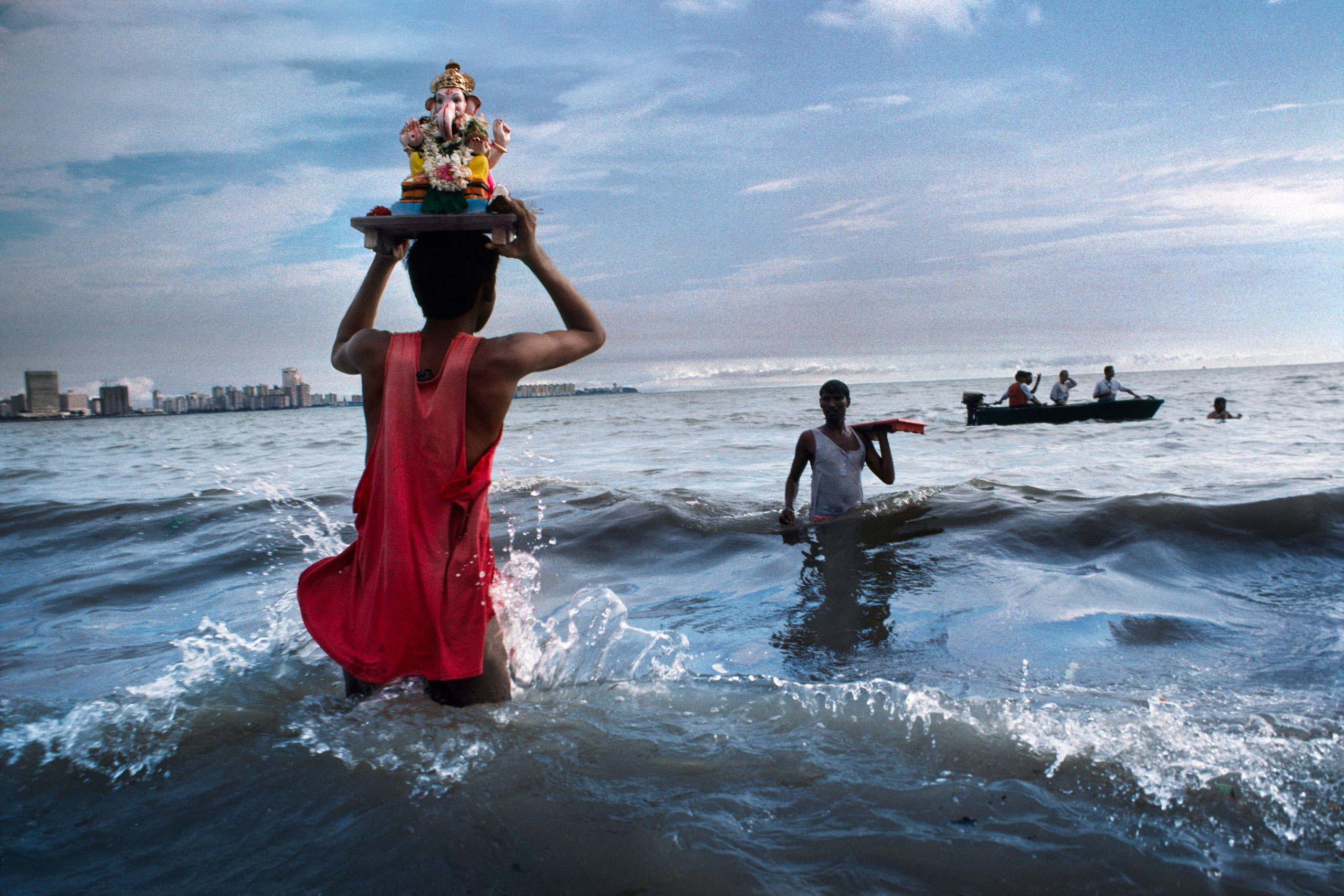 Devotee carries statue of Lord Ganesh into the waters of the Arabian Sea during the immersion ritual off Chowpatty beach.
Mumbai, 1993