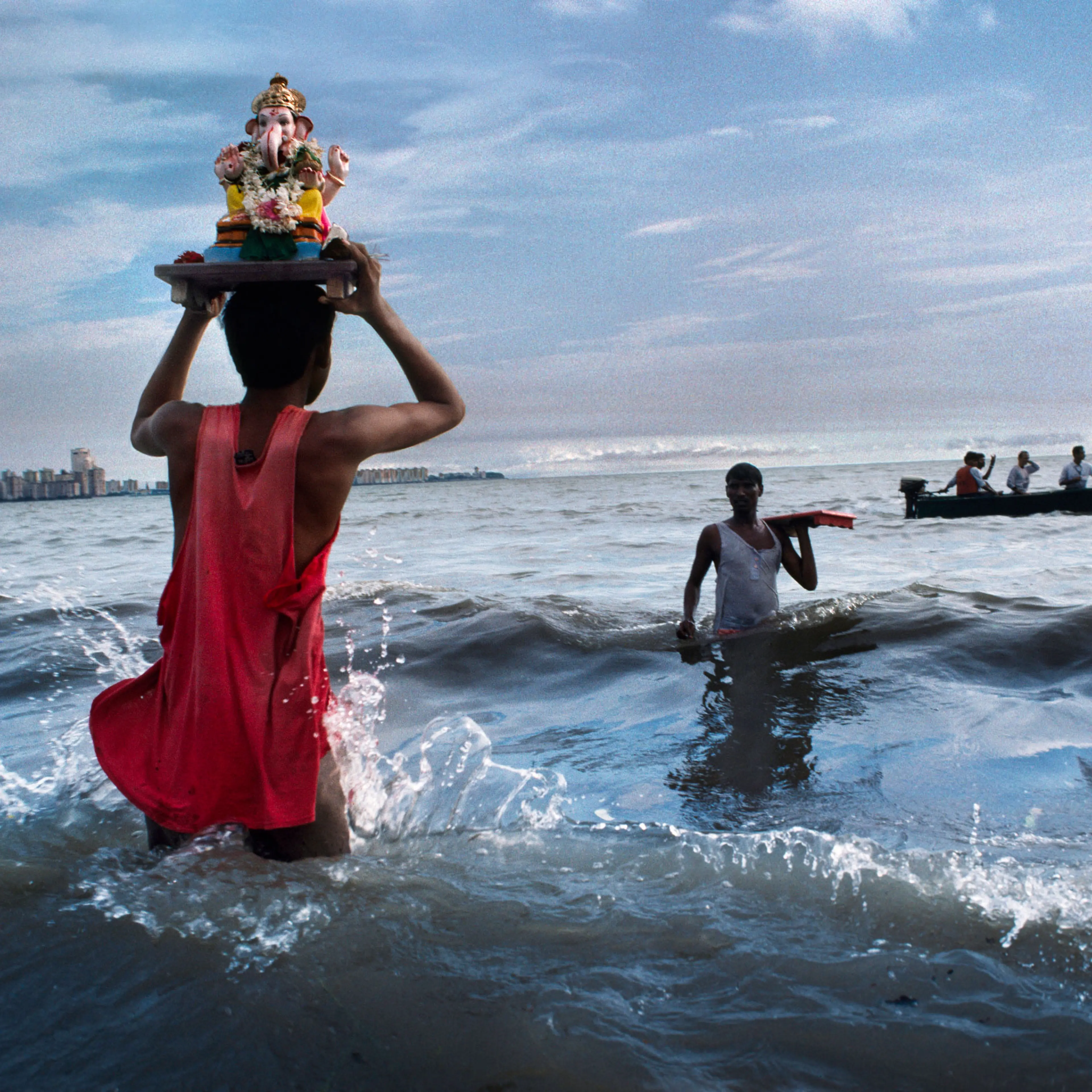 Devotee carries statue of Lord Ganesh into the waters of the Arabian Sea during the immersion ritual off Chowpatty beach.
Mumbai, 1993
