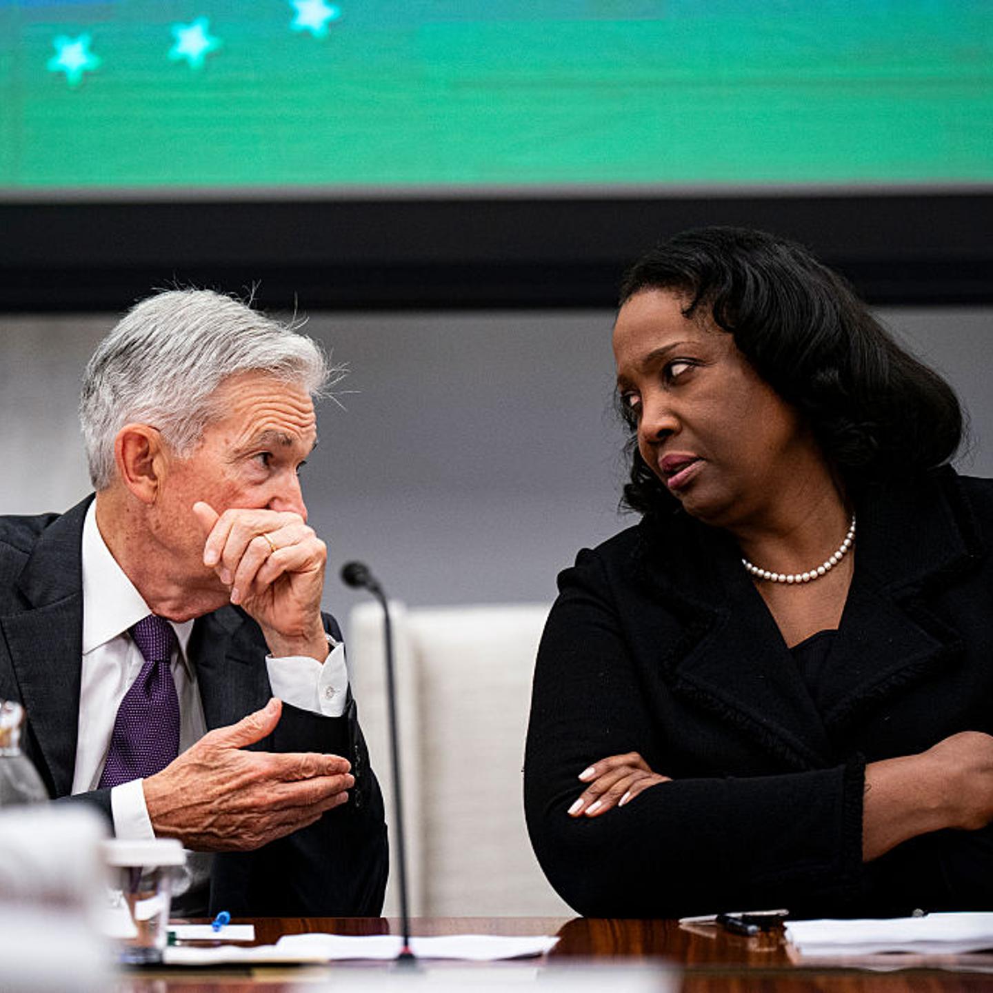 Jerome Powell on the left and Lisa Cook on the right looking at each other