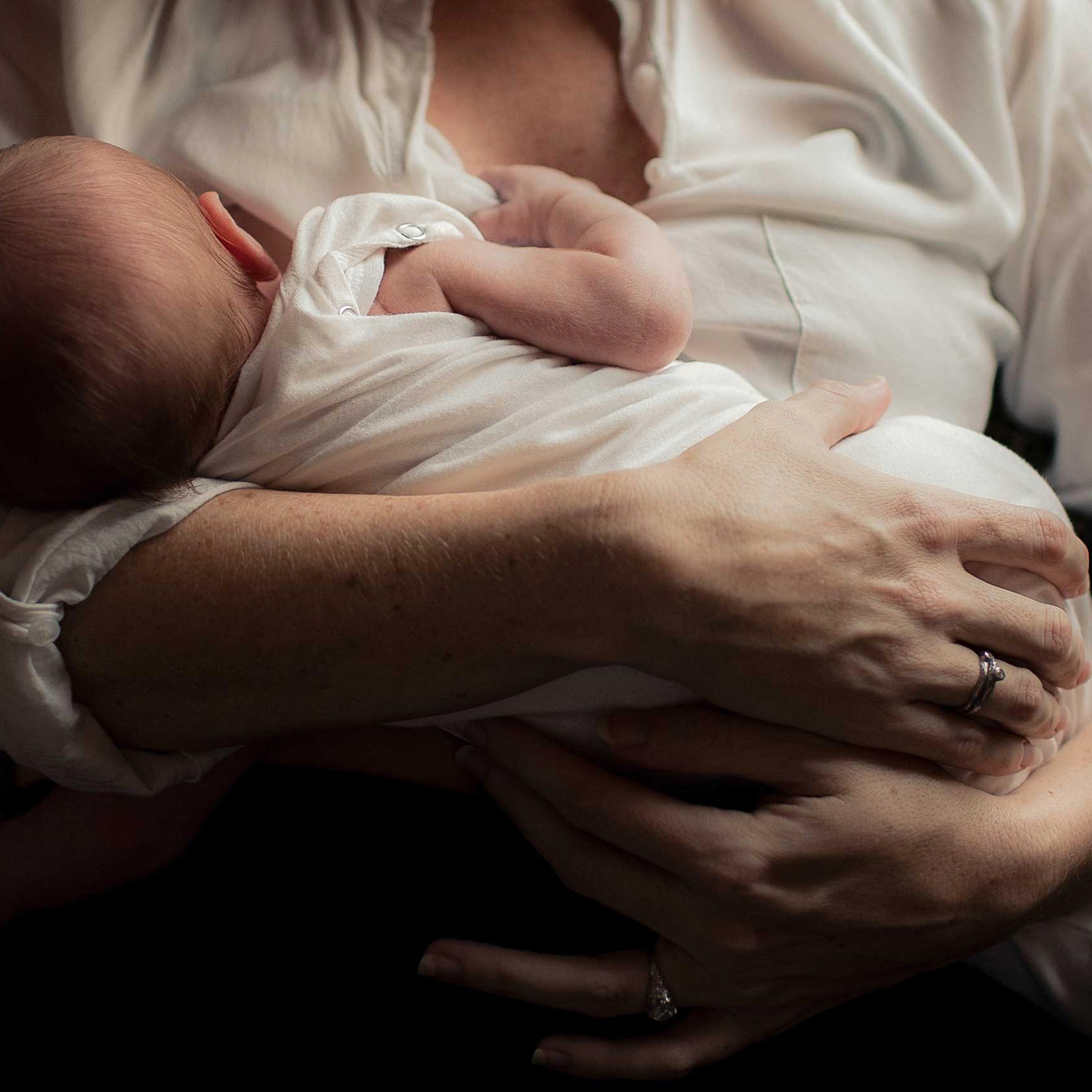 Mother holding newborn baby in arms.