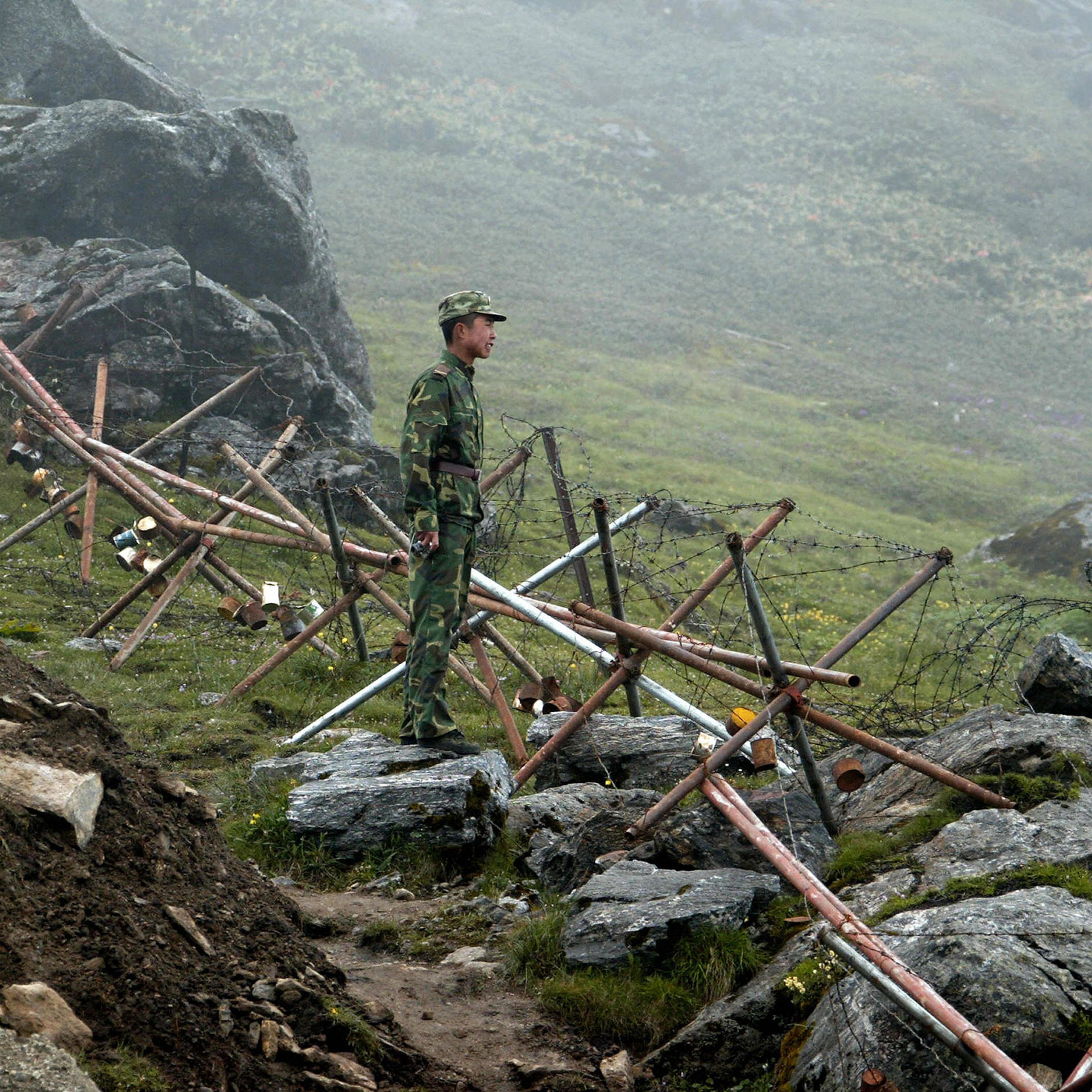 A Chinese soldier stands guard on the Chinese side of the ancient Nathu La border crossing between India and China