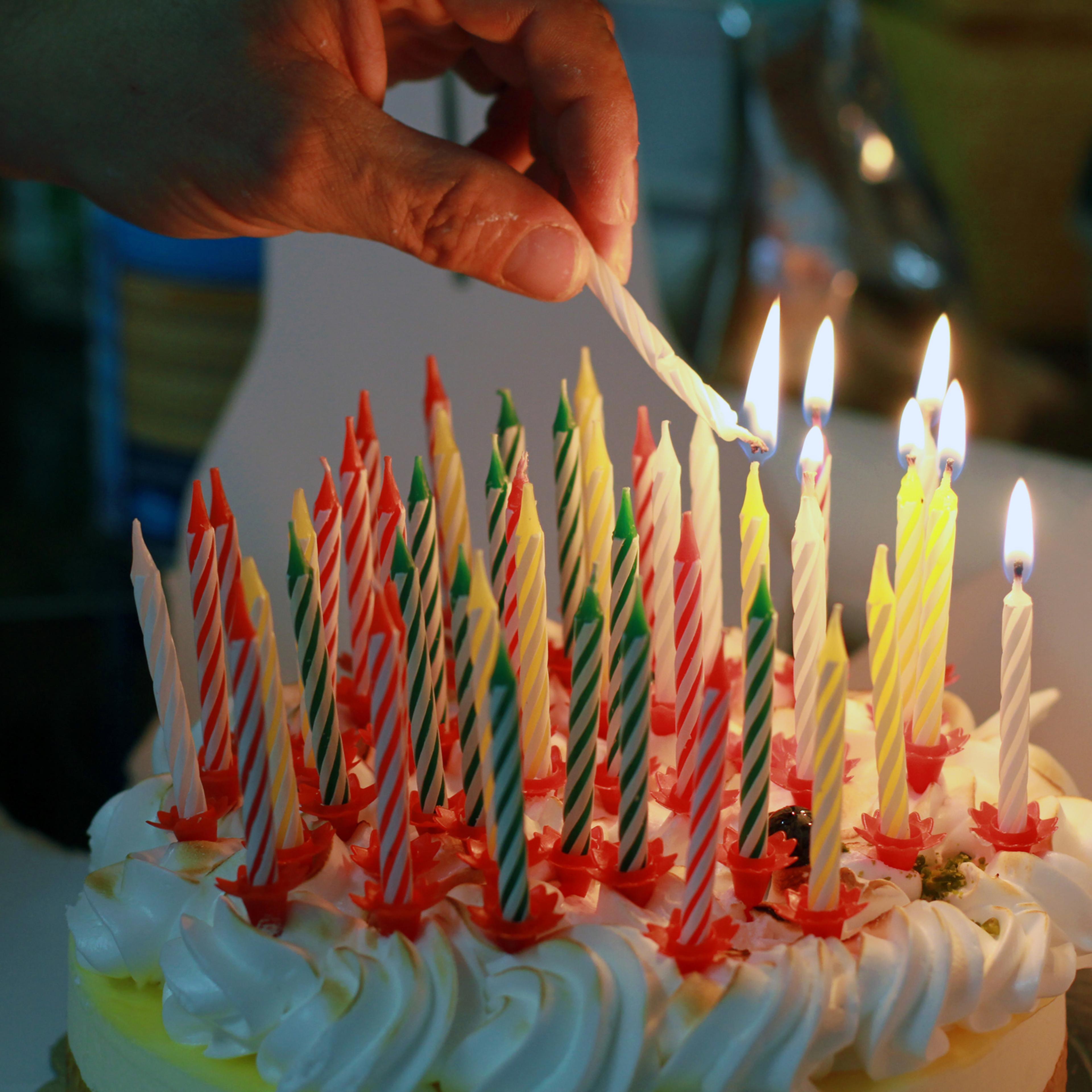 Hand burning candles on birthday cake