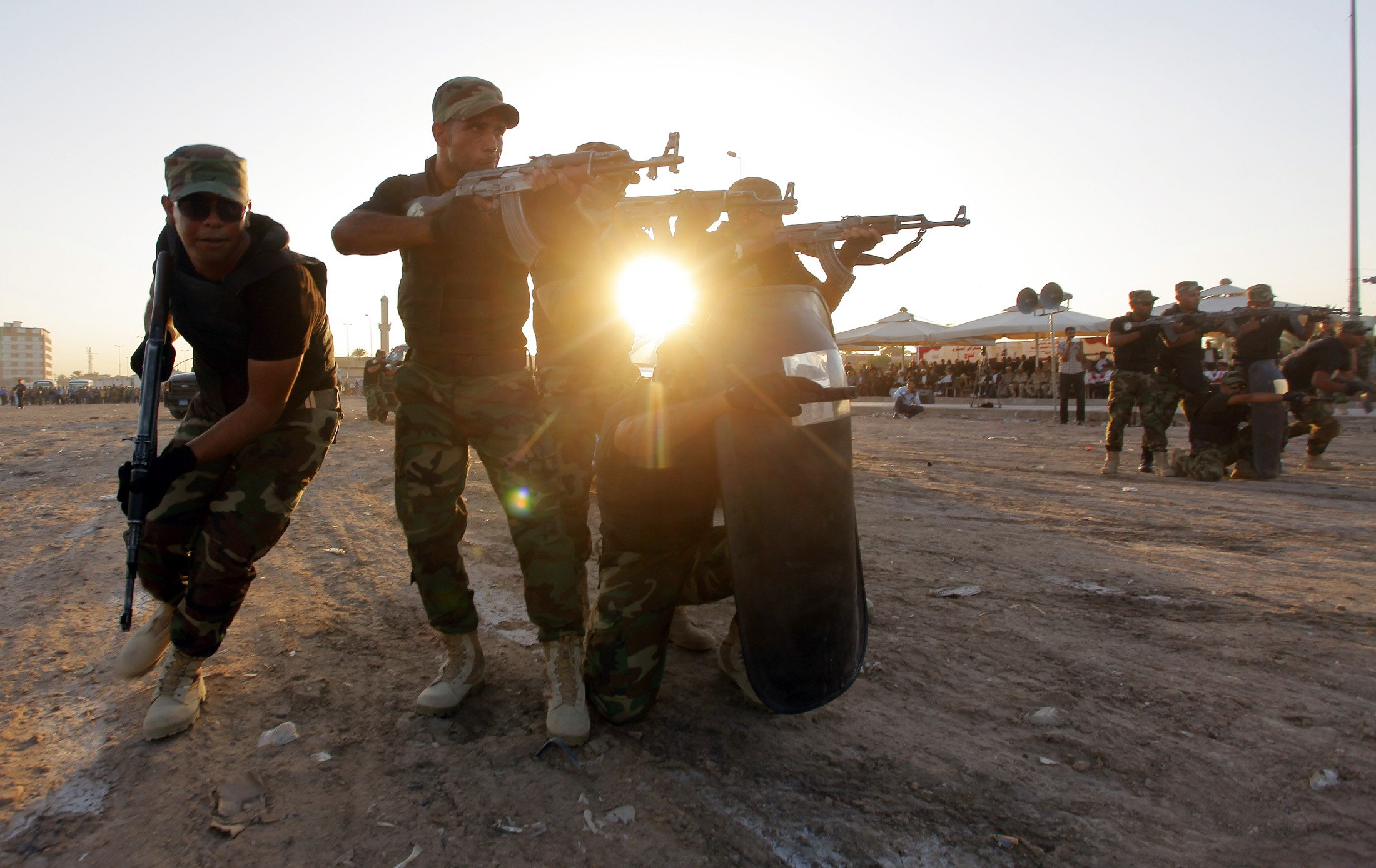 Iraqi Shi'ite volunteers demonstrate their skills during a graduation ceremony in Kufa
