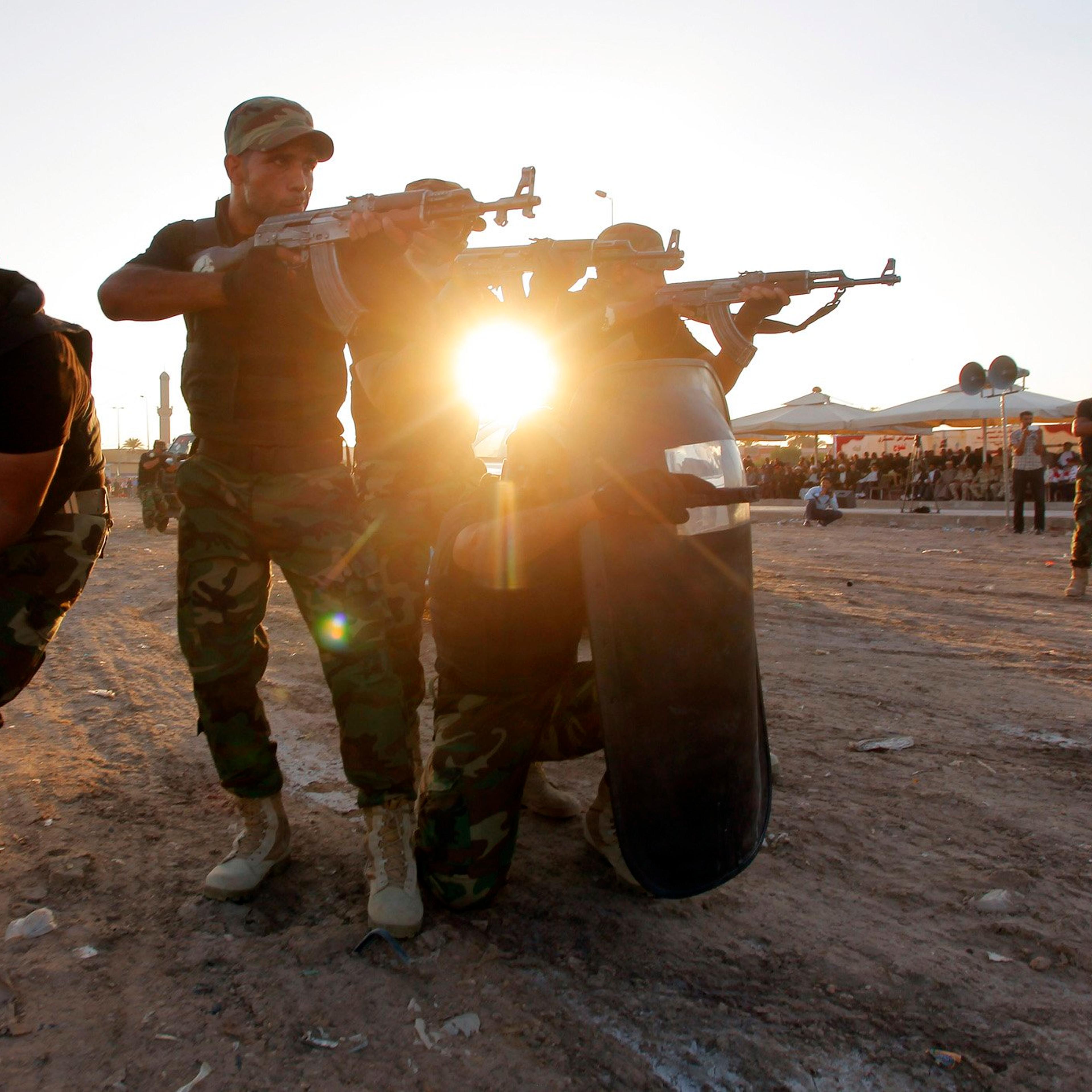 Iraqi Shi'ite volunteers demonstrate their skills during a graduation ceremony in Kufa