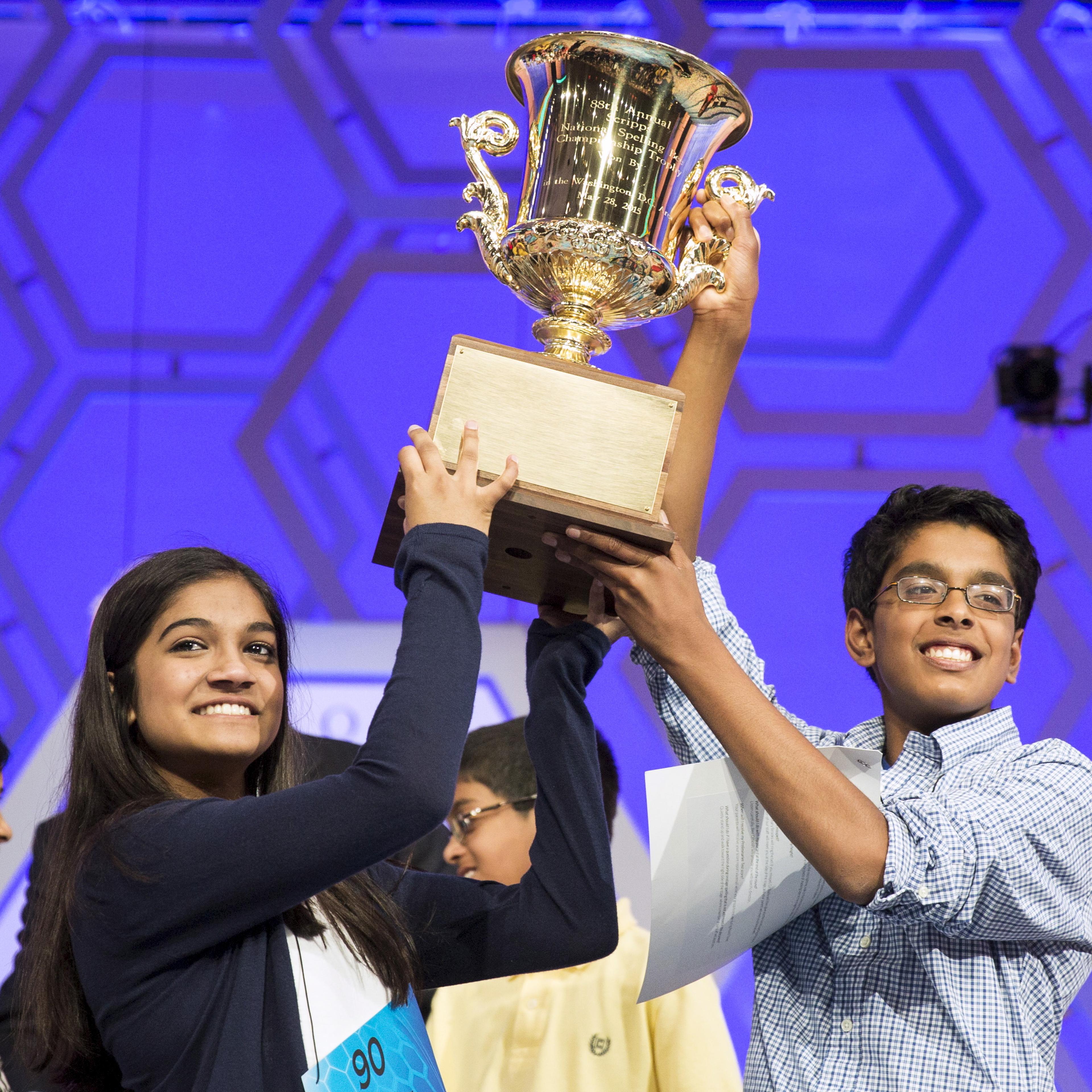 Vanya Shivashankar of Olathe, Kansas, and Gokul Venkatachalam, St. Louis Missouri lift the trophy after becoming co-champions after the final round of the 88th annual Scripps National Spelling Bee