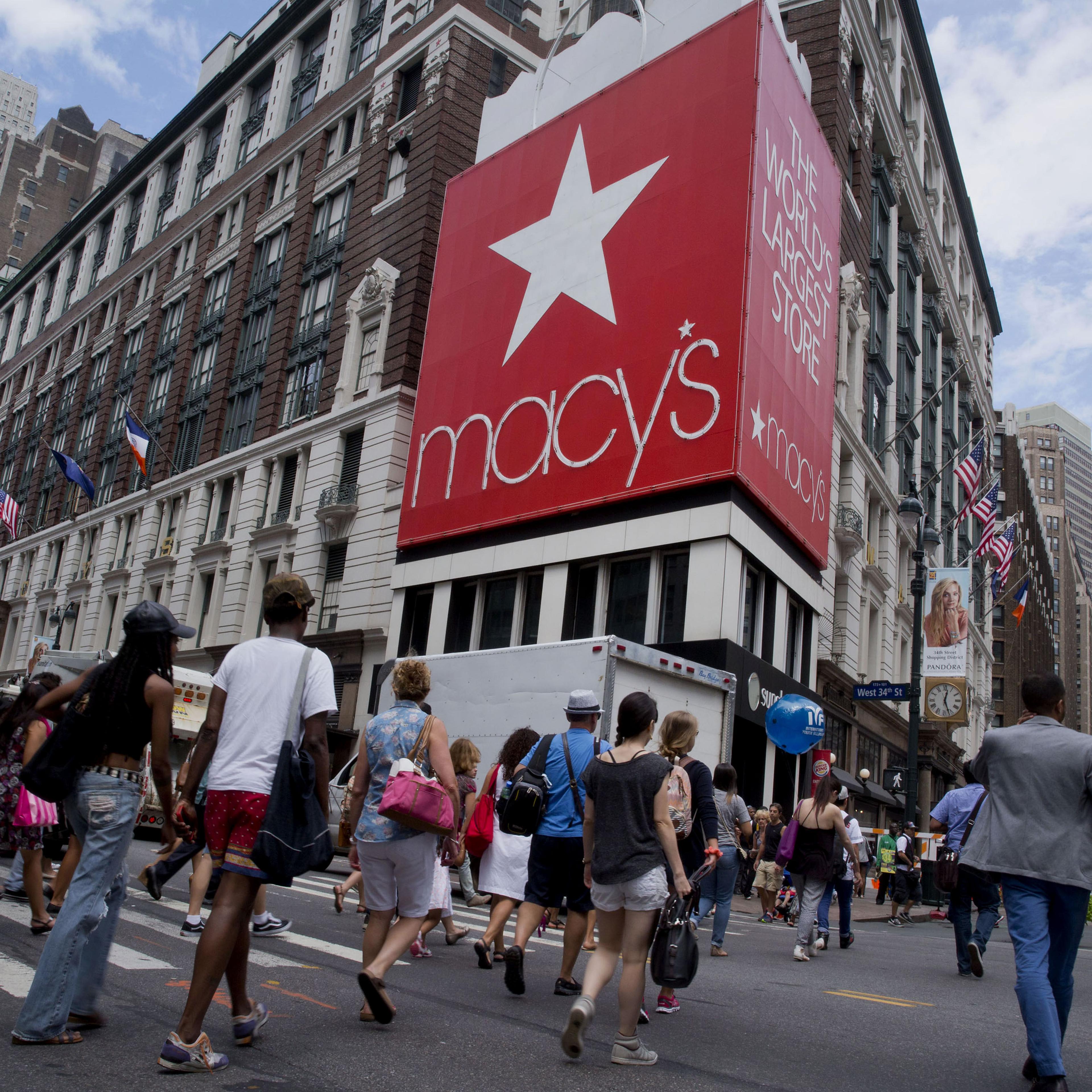 Pedestrians cross the street in front of the Macy's Inc. flagship store in New York City on Aug. 6, 2014.