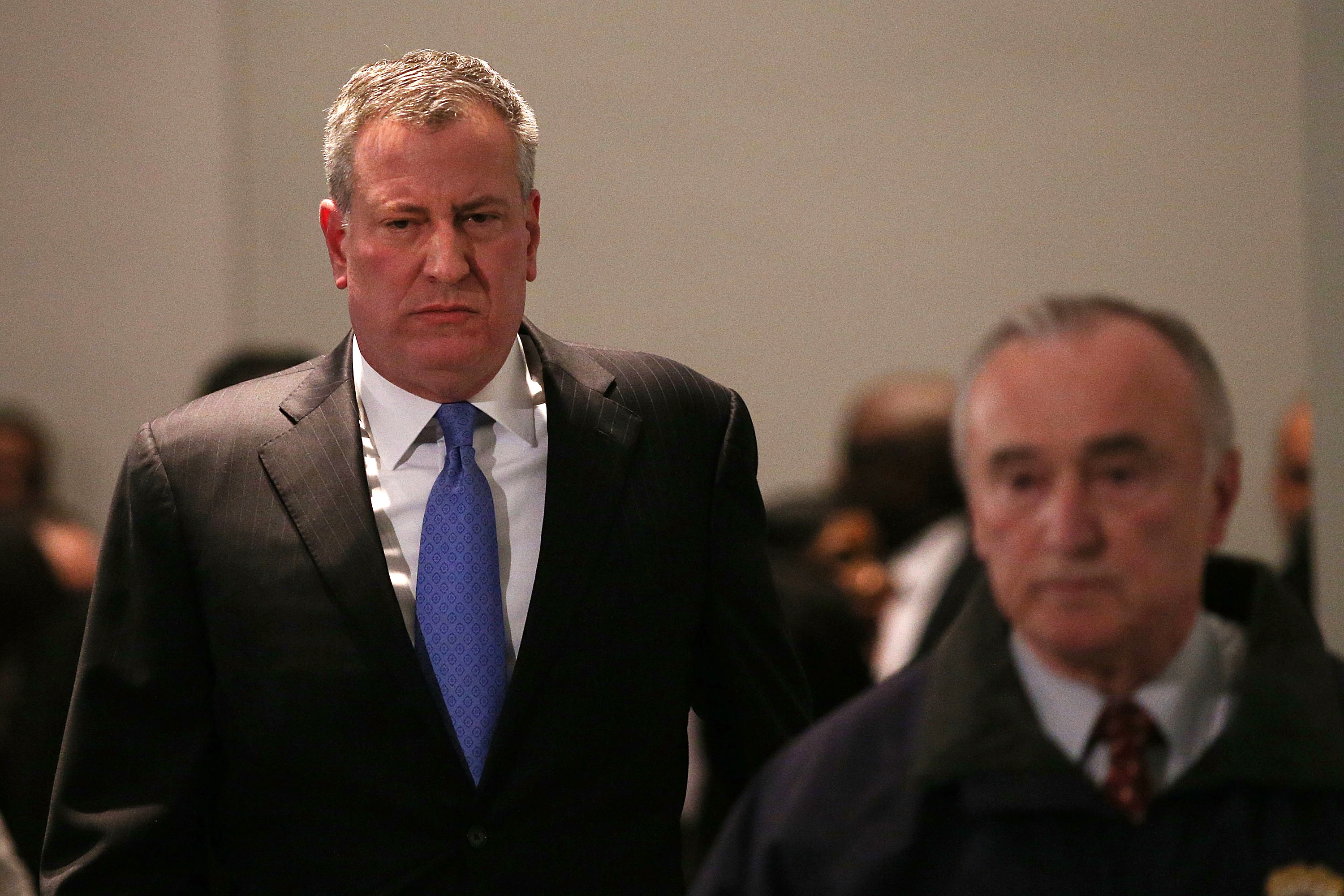 New York City Police Commissioner William J. Bratton is followed by Mayor Bill de Blasio at a news conference at Woodhull Hospital following the killing of two New York City police officers on Dec. 20, 2014 in New York City.