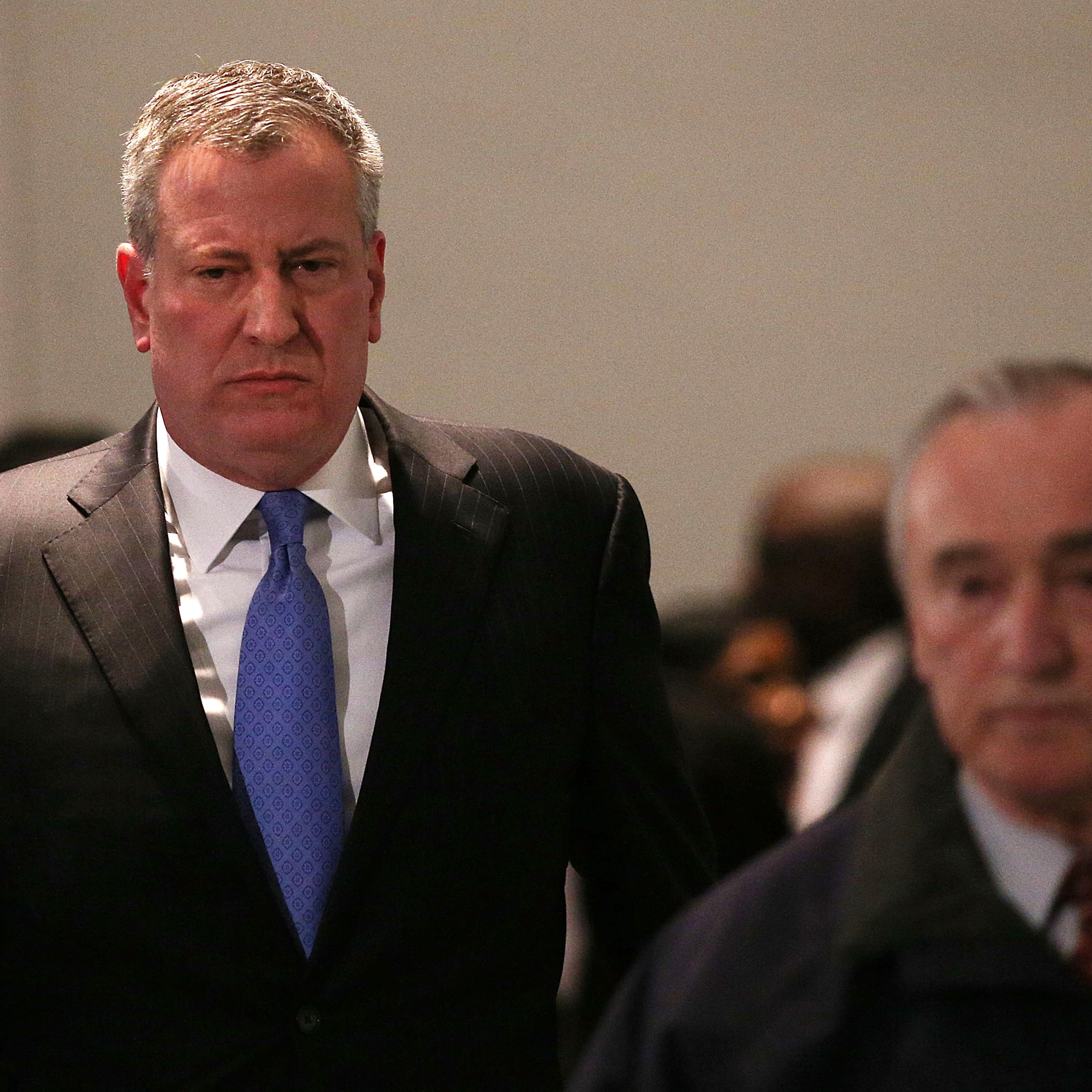New York City Police Commissioner William J. Bratton is followed by Mayor Bill de Blasio at a news conference at Woodhull Hospital following the killing of two New York City police officers on Dec. 20, 2014 in New York City.
