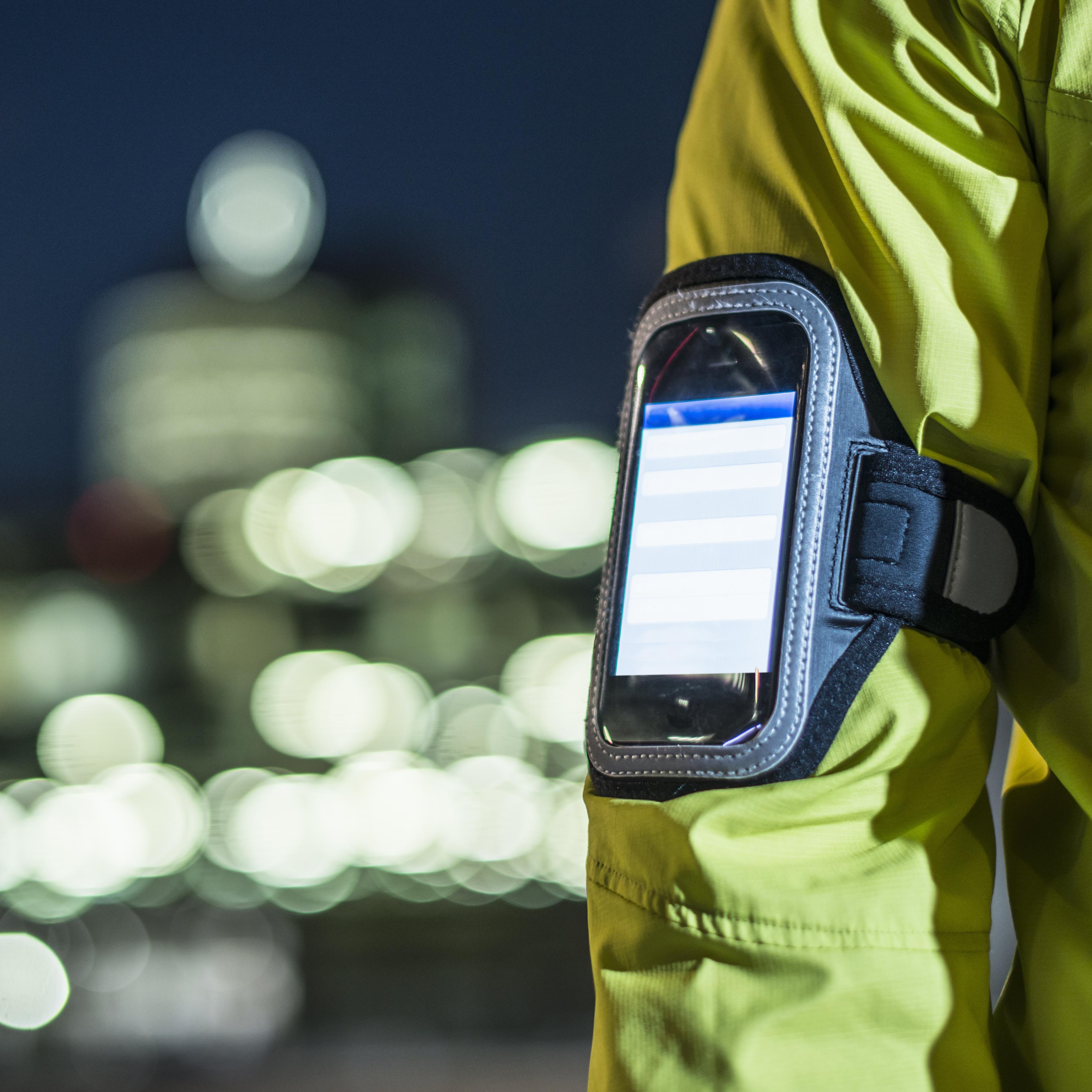 Runner wearing smartphone on arm in city
