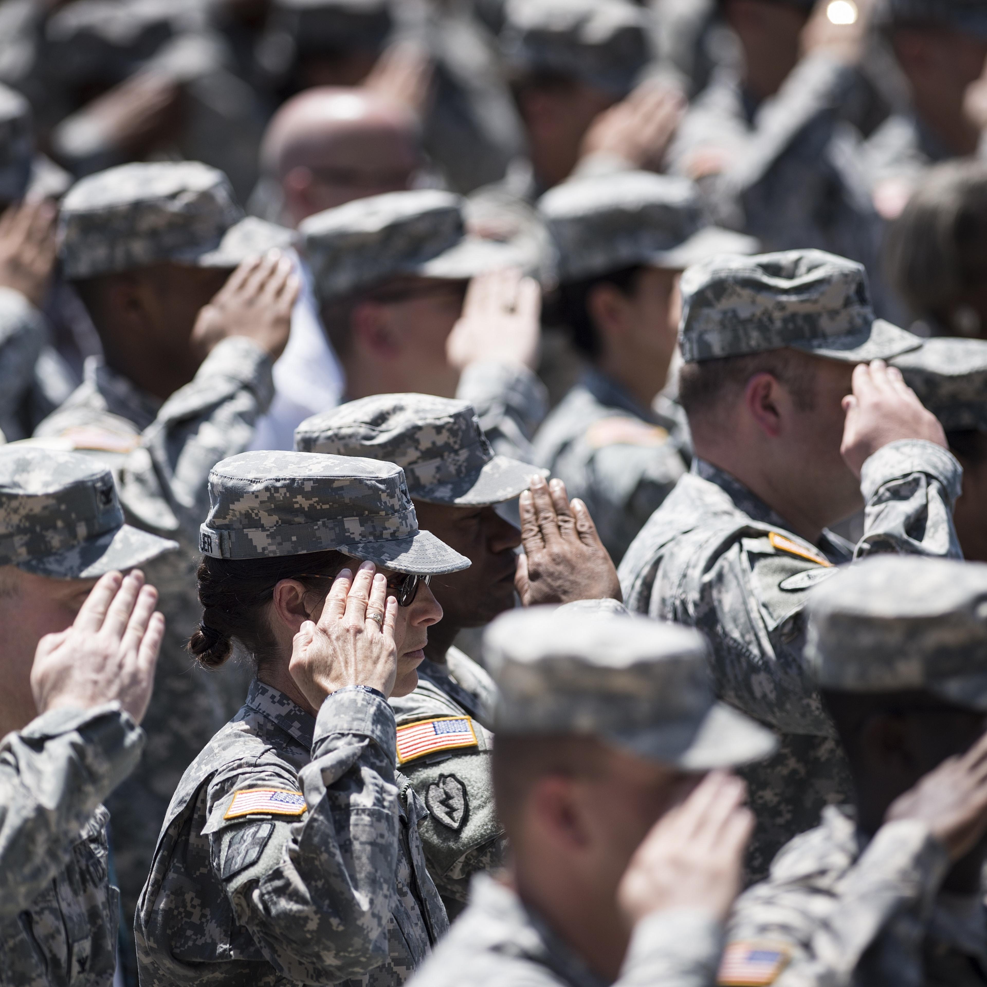 Soldiers listen to the US national anthem during a memorial service at Fort Hood in Texas on April 9, 2014.