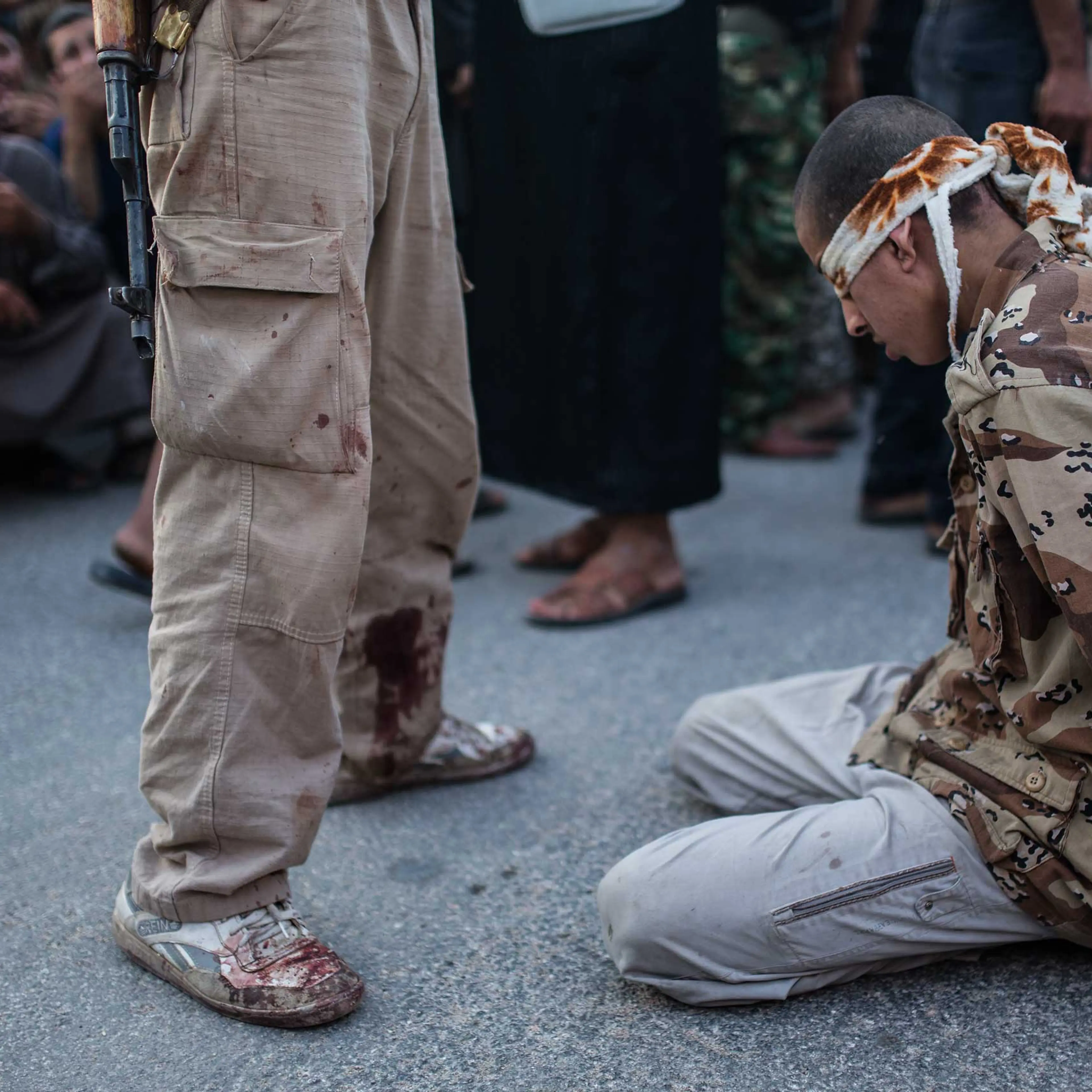 A young Syrian man kneels blindfolded before anti-regime rebels publicly executed him in the town of Keferghan, near Aleppo, on August 31, 2013.
