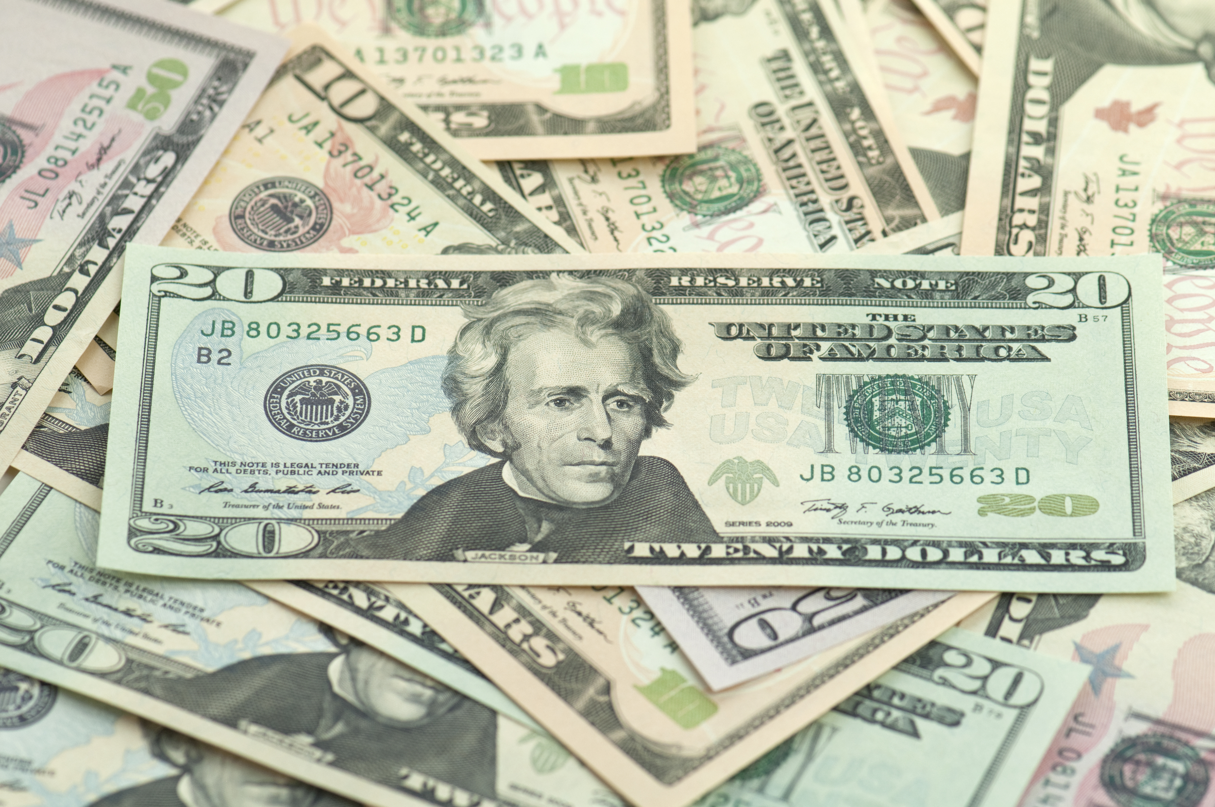 Pile of new series American money twenty on top.