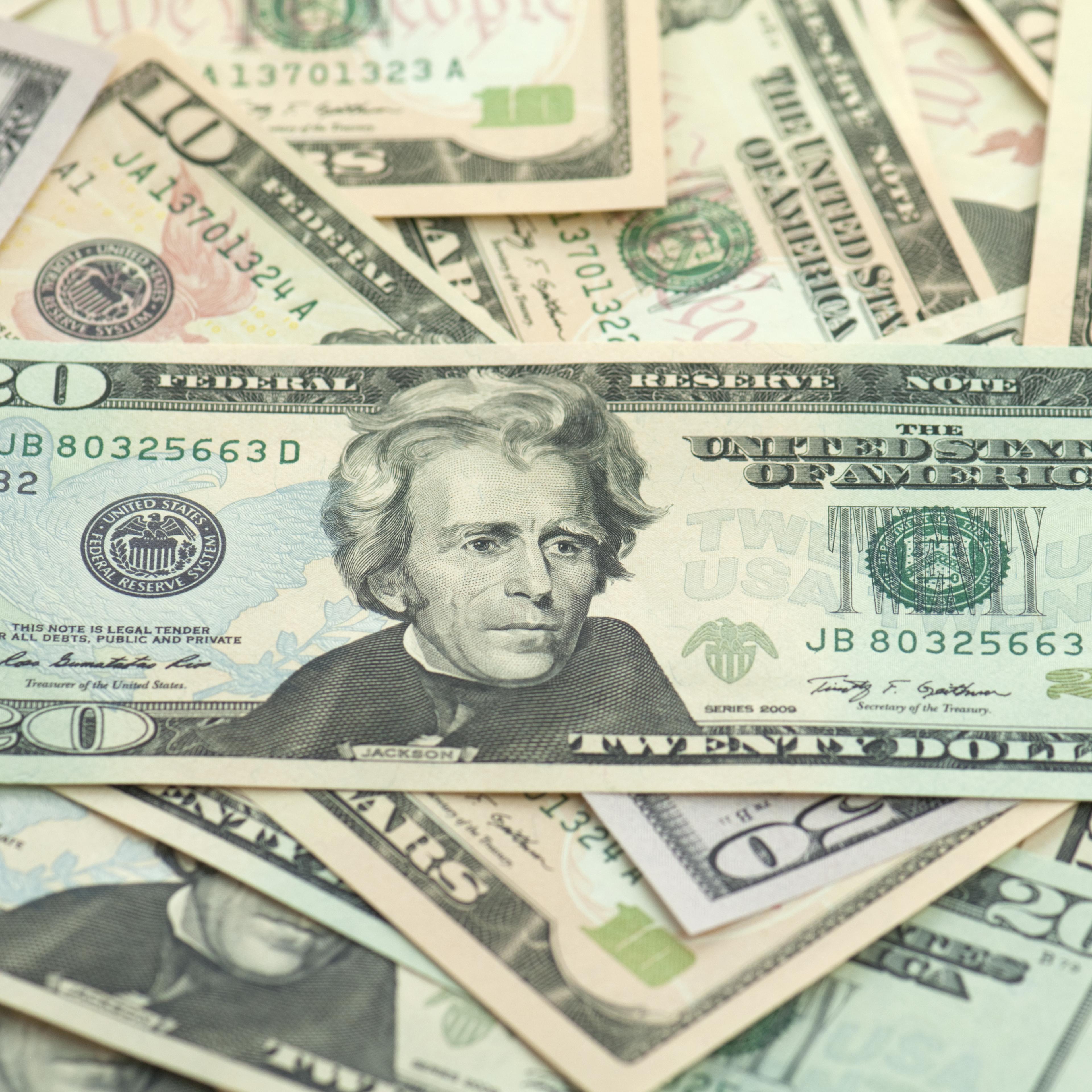 Pile of new series American money twenty on top.