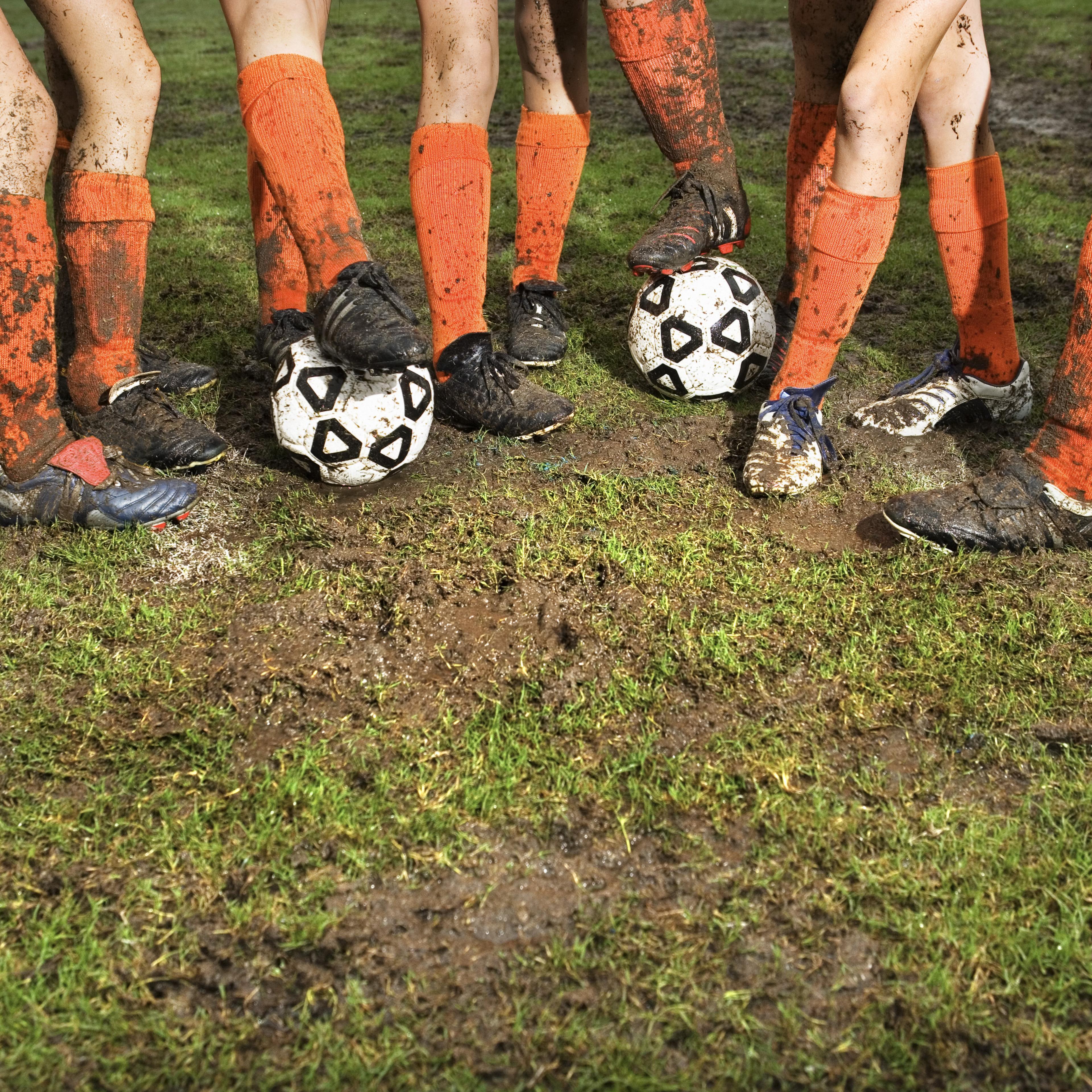 Muddy legs of soccer players