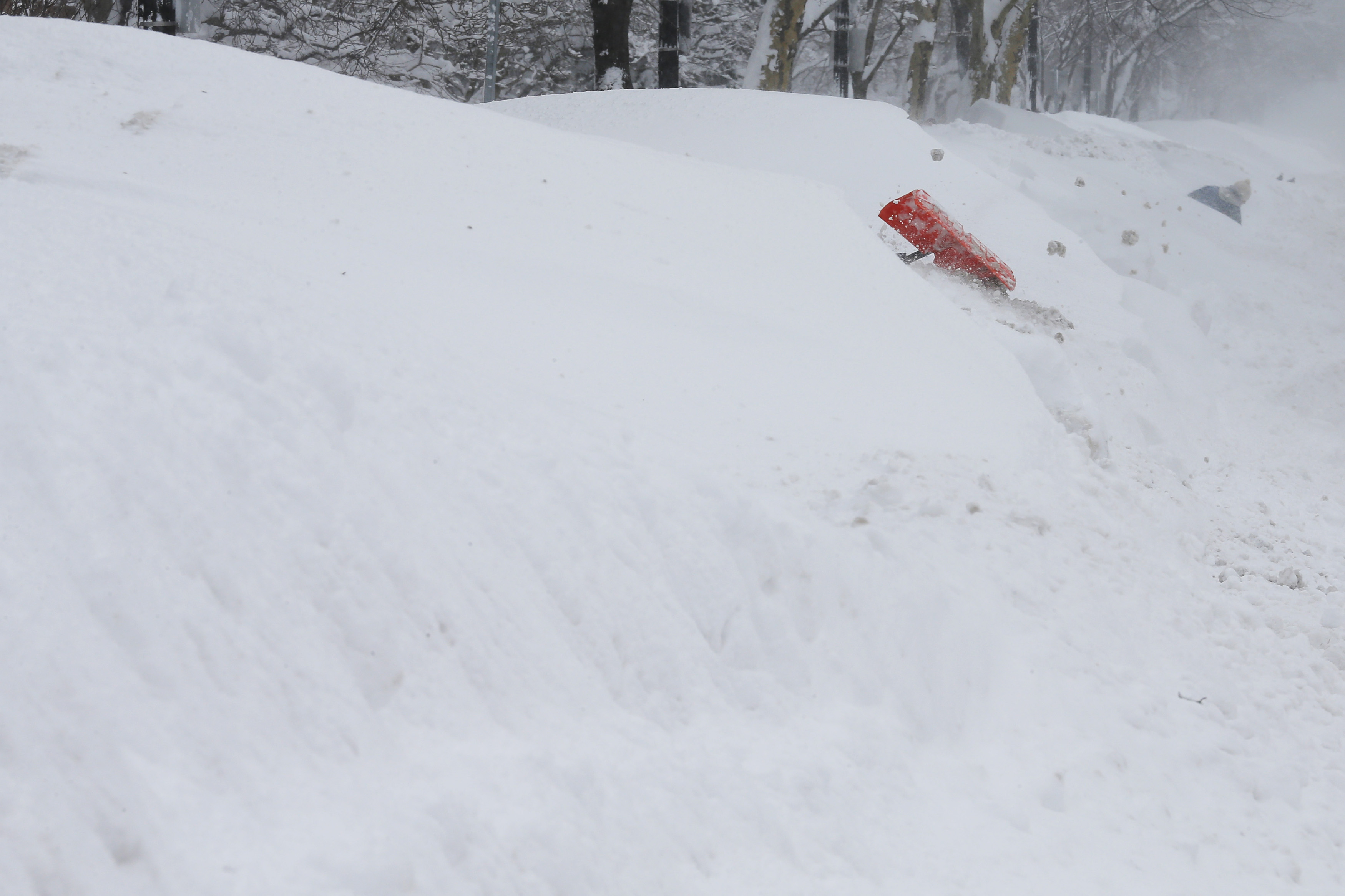 Worker digs a path through the large snow mounds on Beacon Street during a winter blizzard in Boston