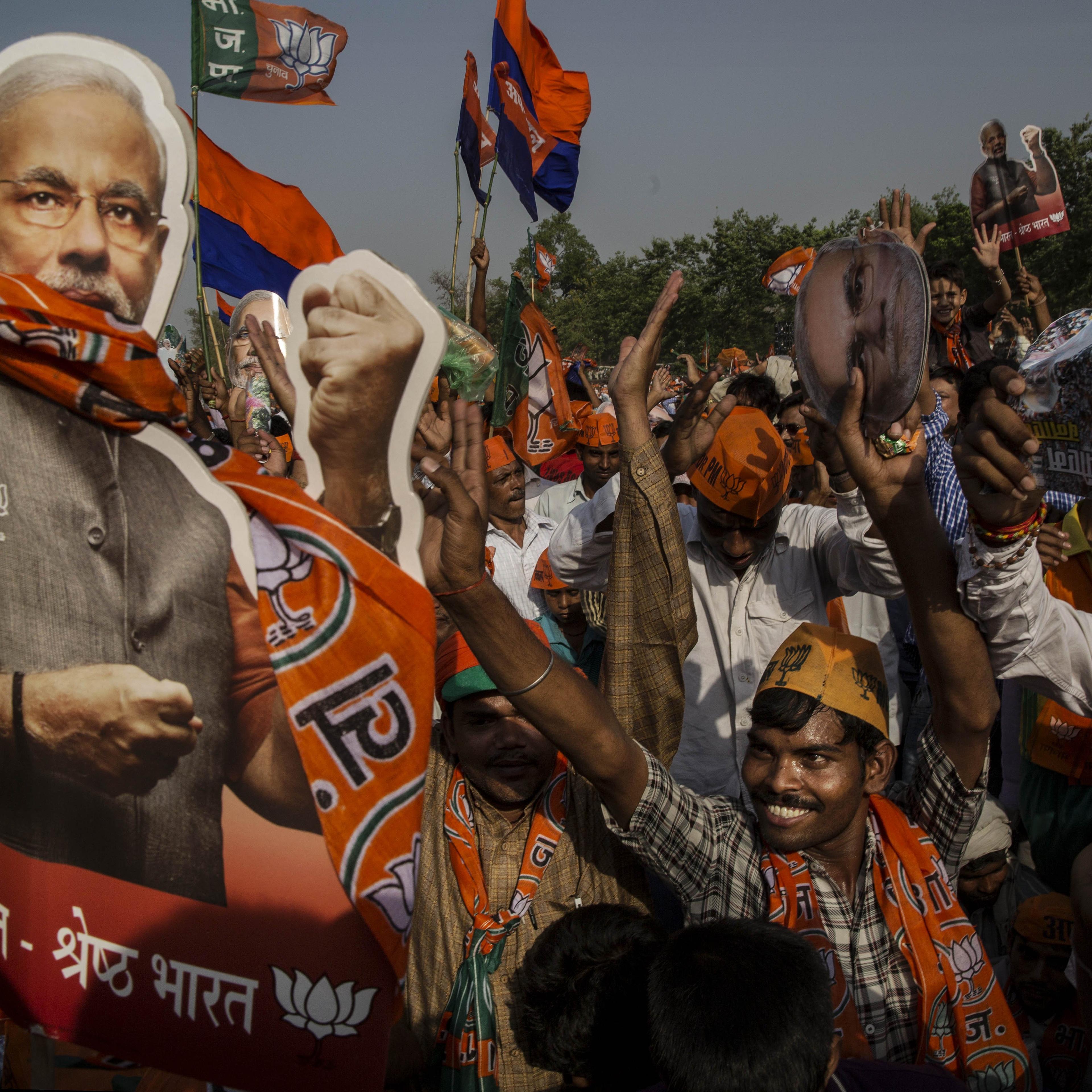 Supporters of BJP leader Narendra Modi cheer during his speech at a rally by the leader on May 8, 2014 in Rohaniya, near Varanasi.