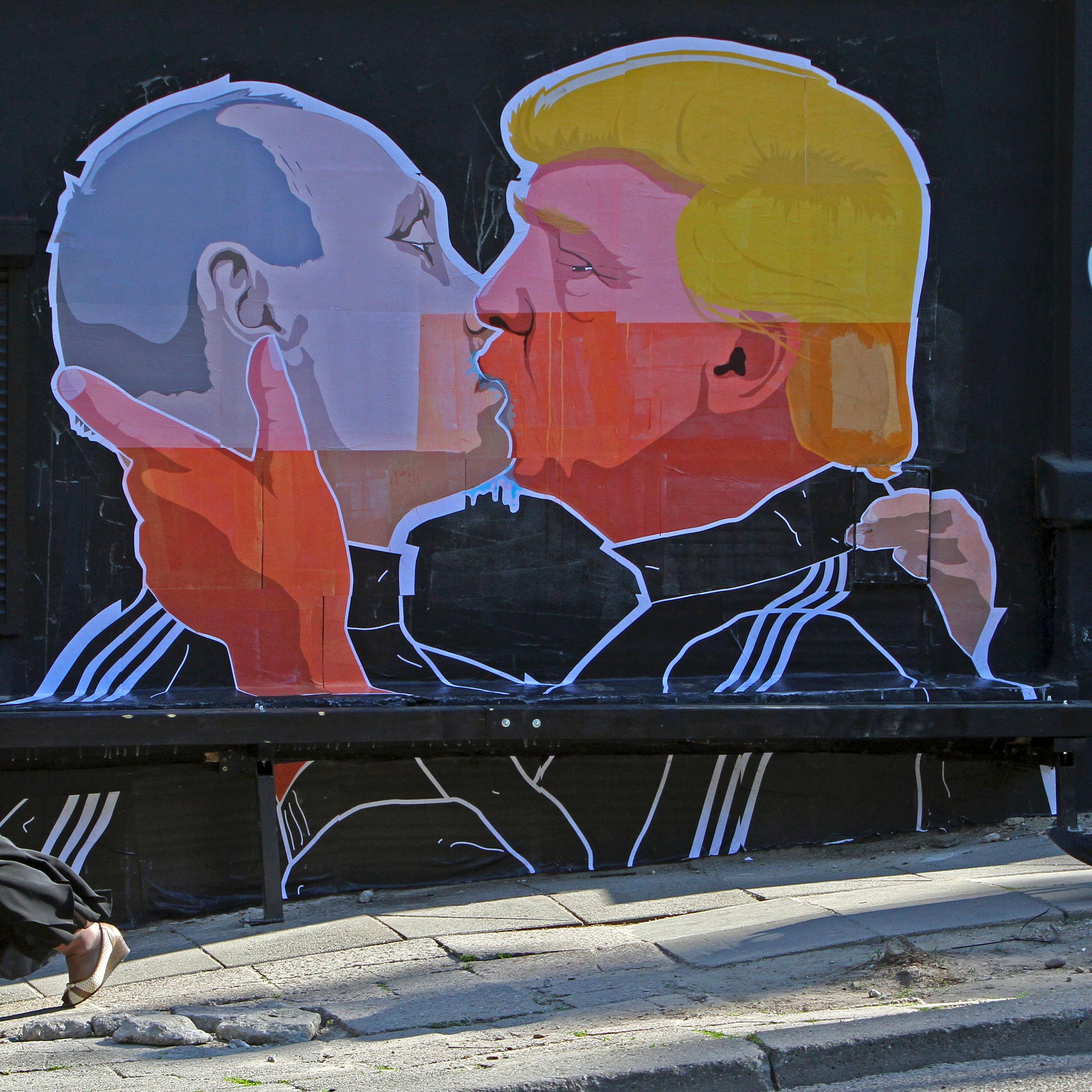 People walk past a mural on a restaurant wall depicting U.S. Presidential hopeful Donald Trump and Russian President Vladimir Putin greeting each other with a kiss in the Lithuanian capital Vilnius on May 13, 2016.