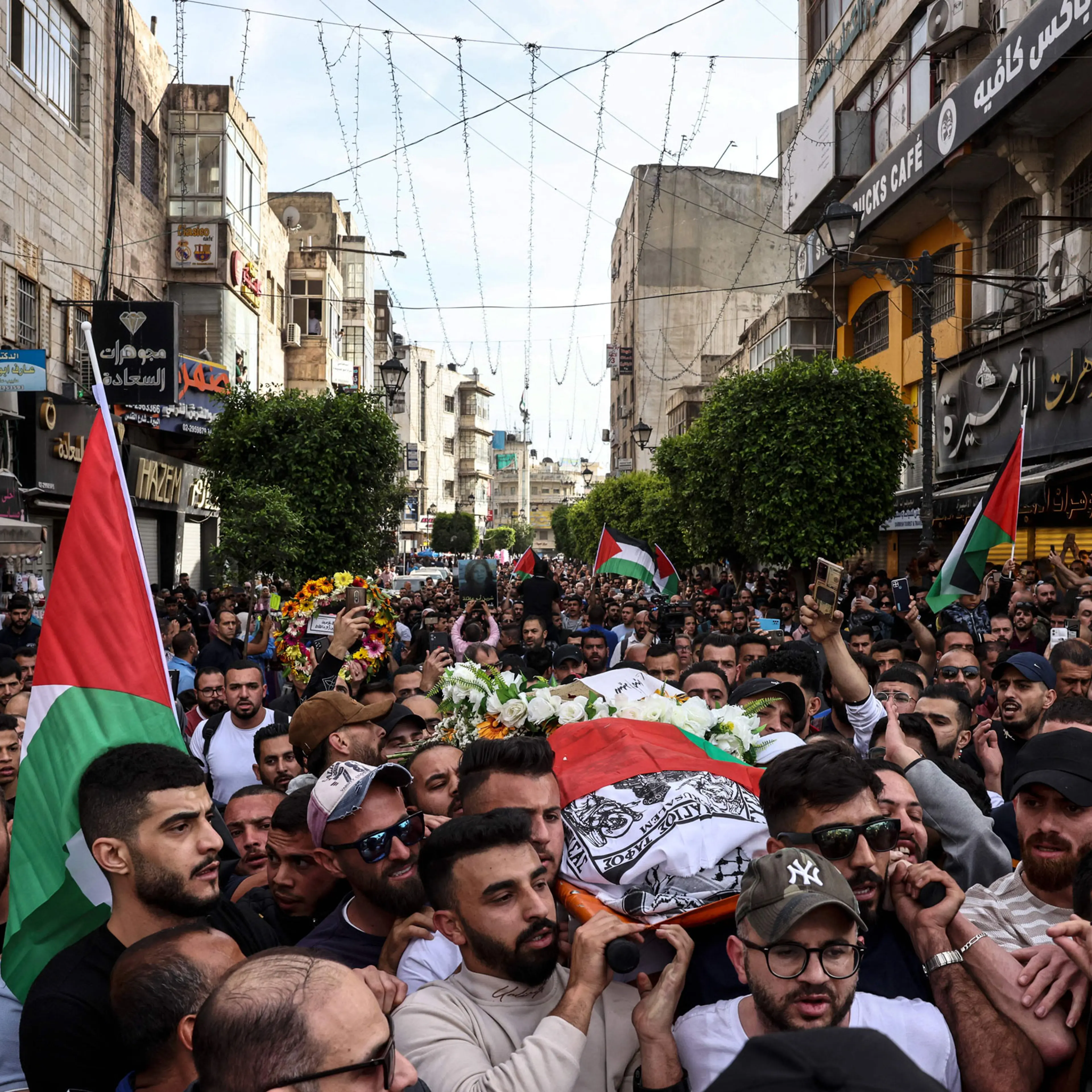 Palestinians carry the flag-draped body of veteran Al-Jazeera journalist Shireen Abu Akleh