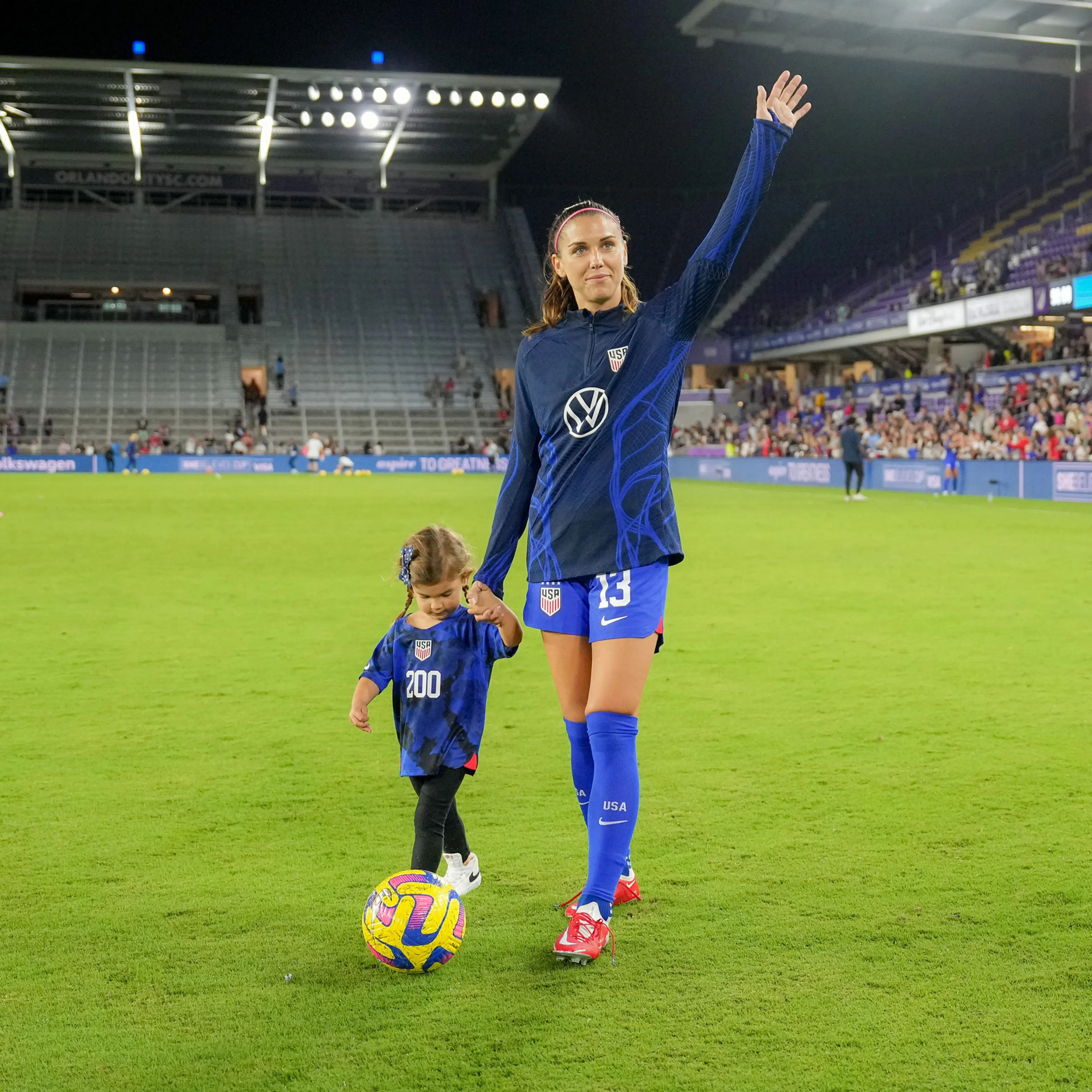 Alex Morgan and her daughter Charlie on the field