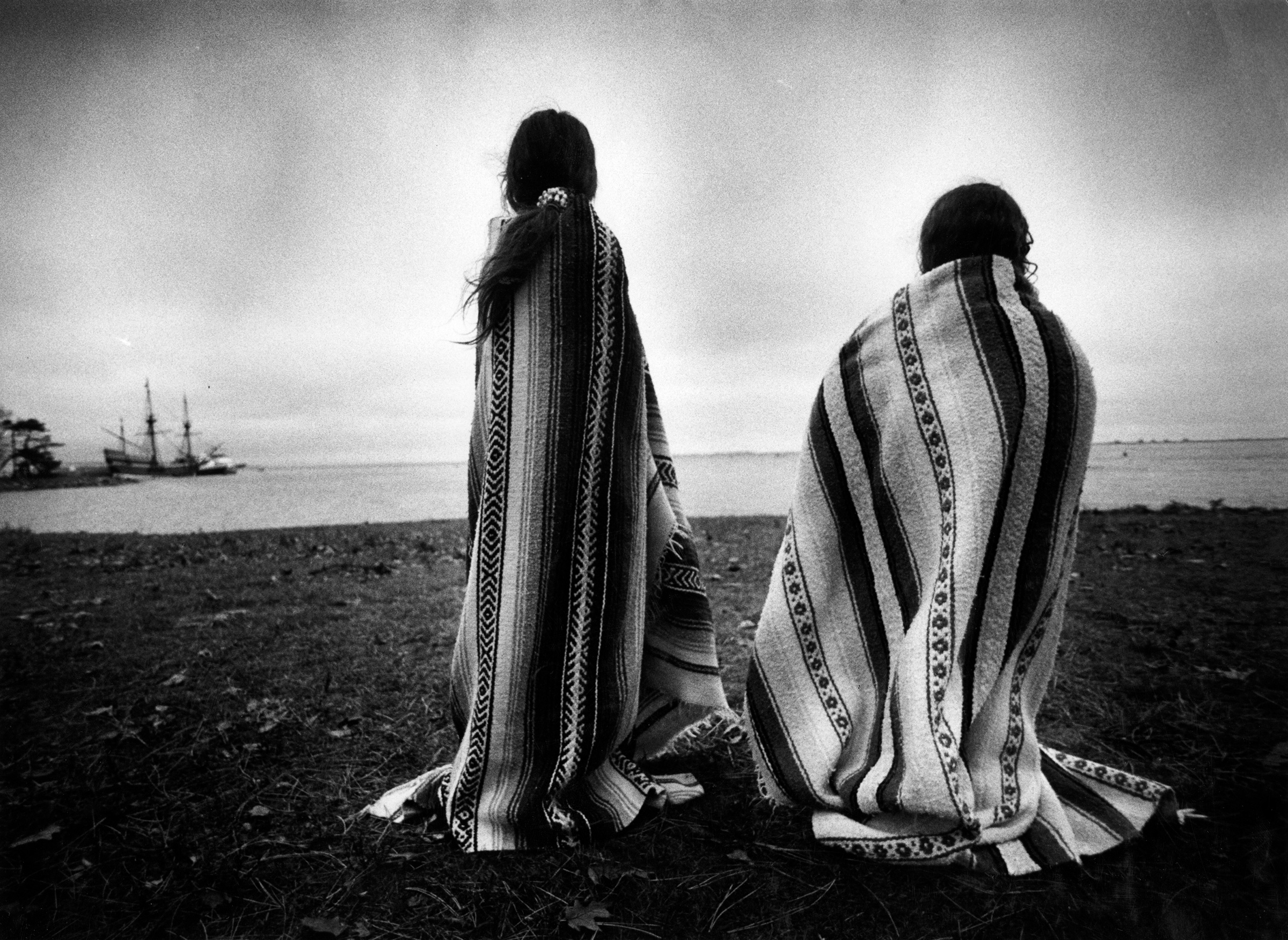 Weetoomoo Carey, 8, left, and Jackolynn Carey, 5, Wampanoag Nipmucs from Mashpee, look across to the Mayflower replica anchored near Plymouth Rock on Nov. 26, 1991. They were with a group of Native Americans gathered for a day of mourning in response to 