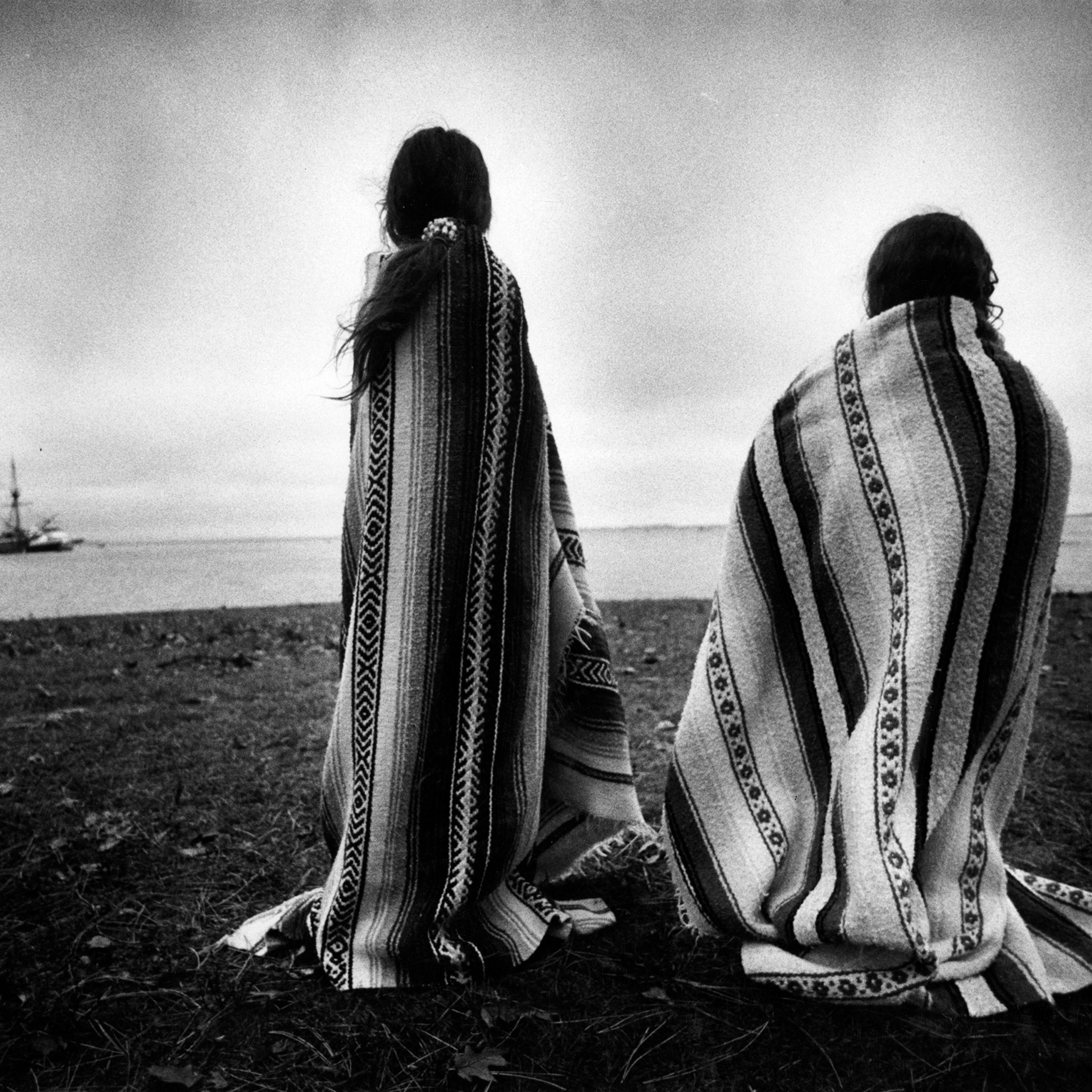 Weetoomoo Carey, 8, left, and Jackolynn Carey, 5, Wampanoag Nipmucs from Mashpee, look across to the Mayflower replica anchored near Plymouth Rock on Nov. 26, 1991. They were with a group of Native Americans gathered for a day of mourning in response to