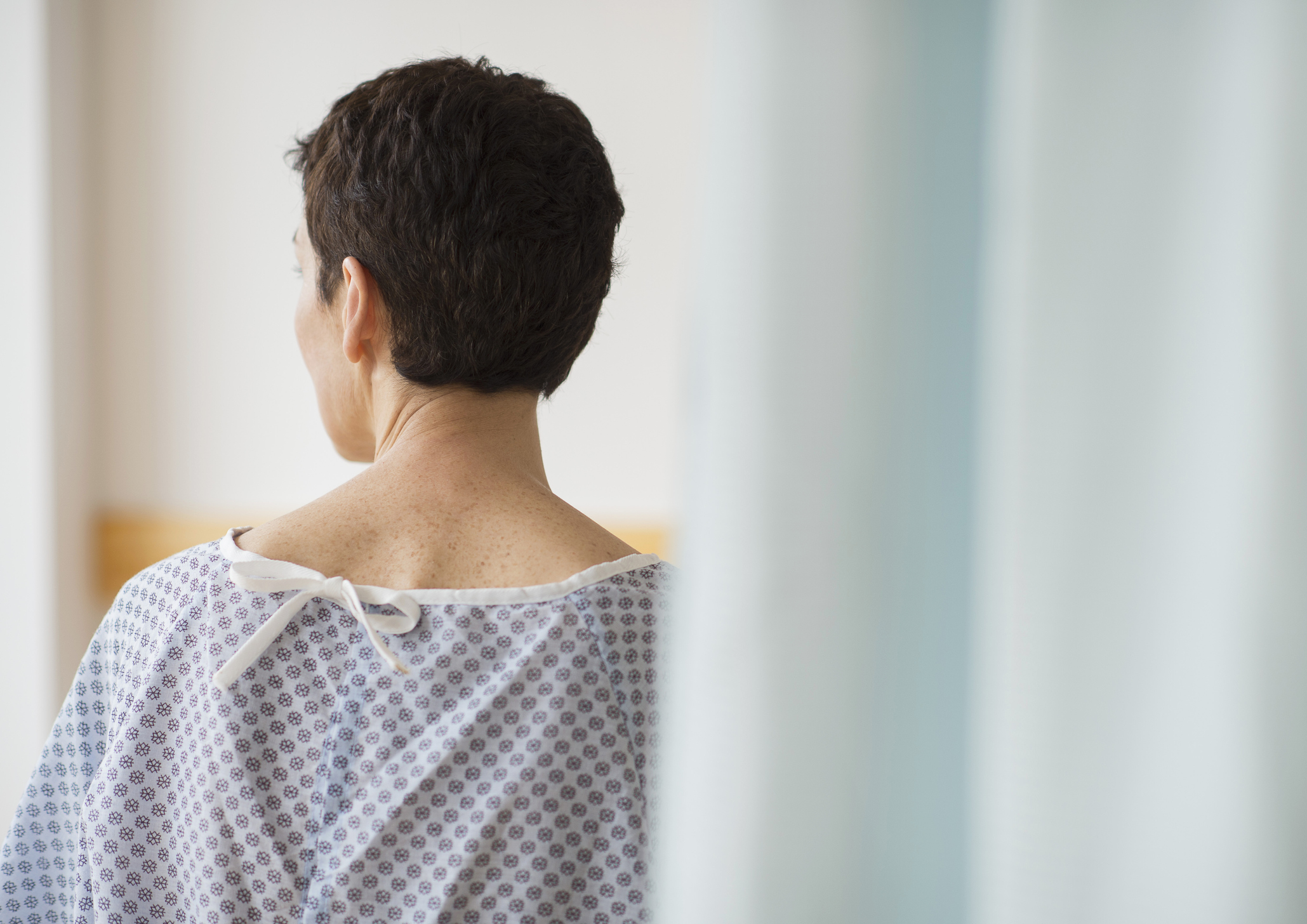 USA, New Jersey, Jersey City, Rear view of senior woman wearing hospital gown