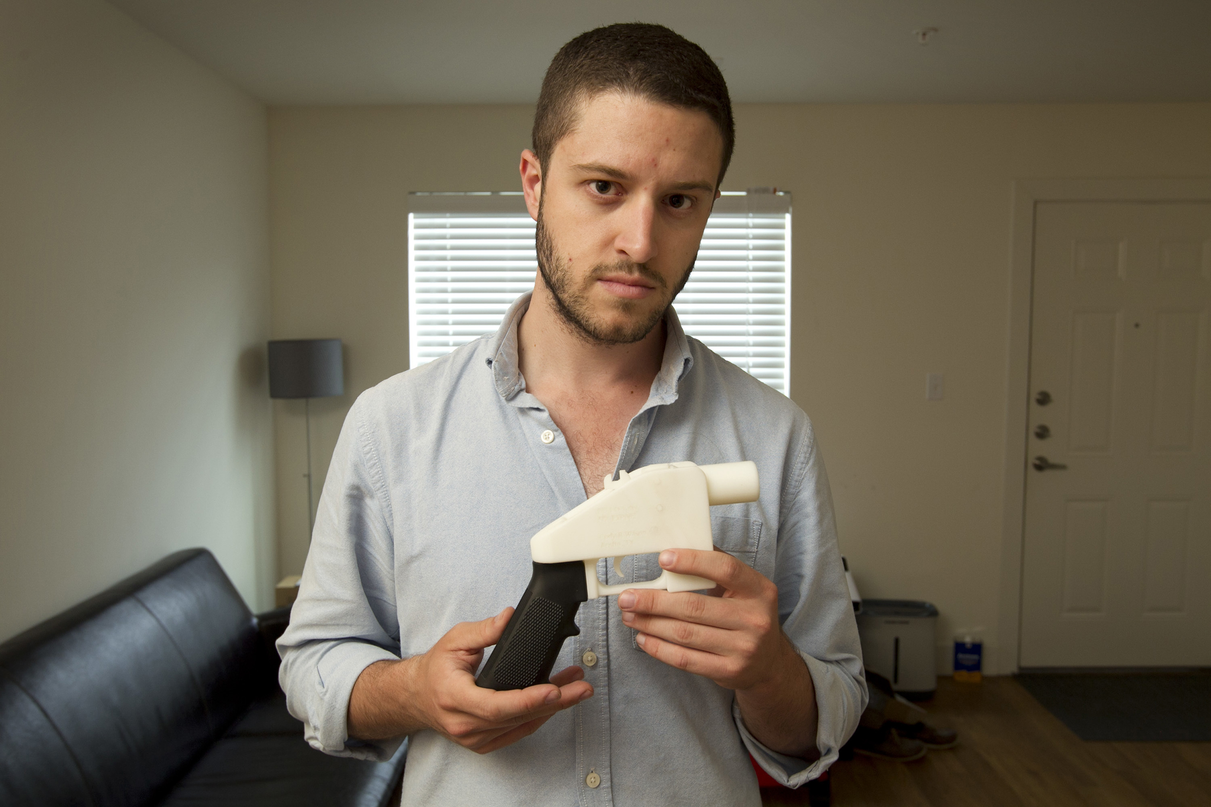 In this May 10, 2013 photo, Cody Wilson, the founder of Defense Distributed, shows a plastic handgun made on a 3D-printer at his home in Austin, Texas.