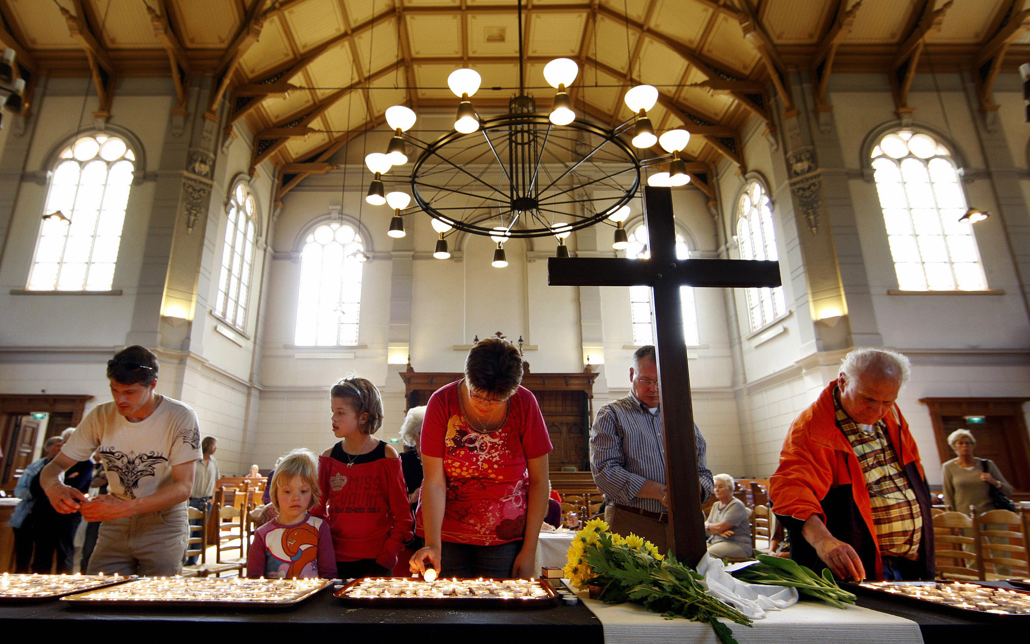 People burn candles at a church at for t