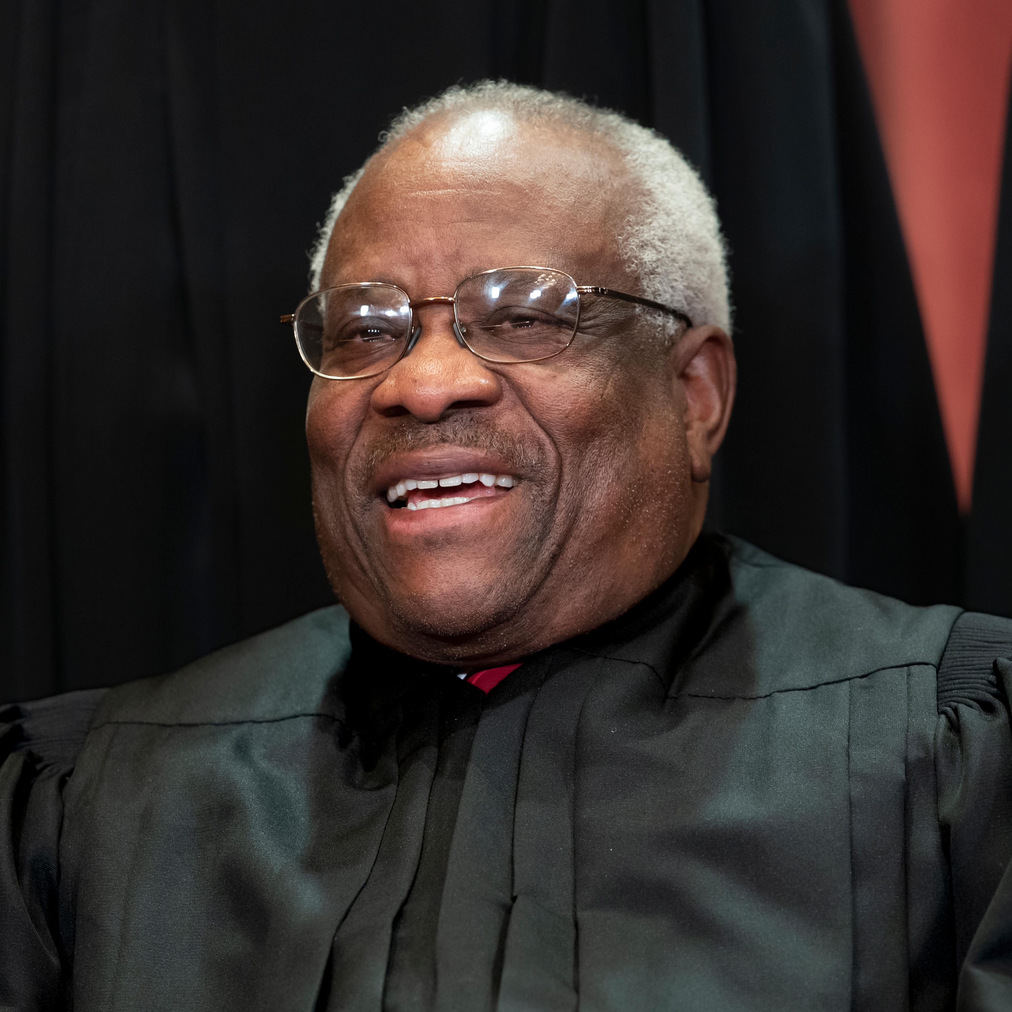 Associate Justice Clarence Thomas sits with fellow Supreme Court justices for a group portrait at the Supreme Court Building