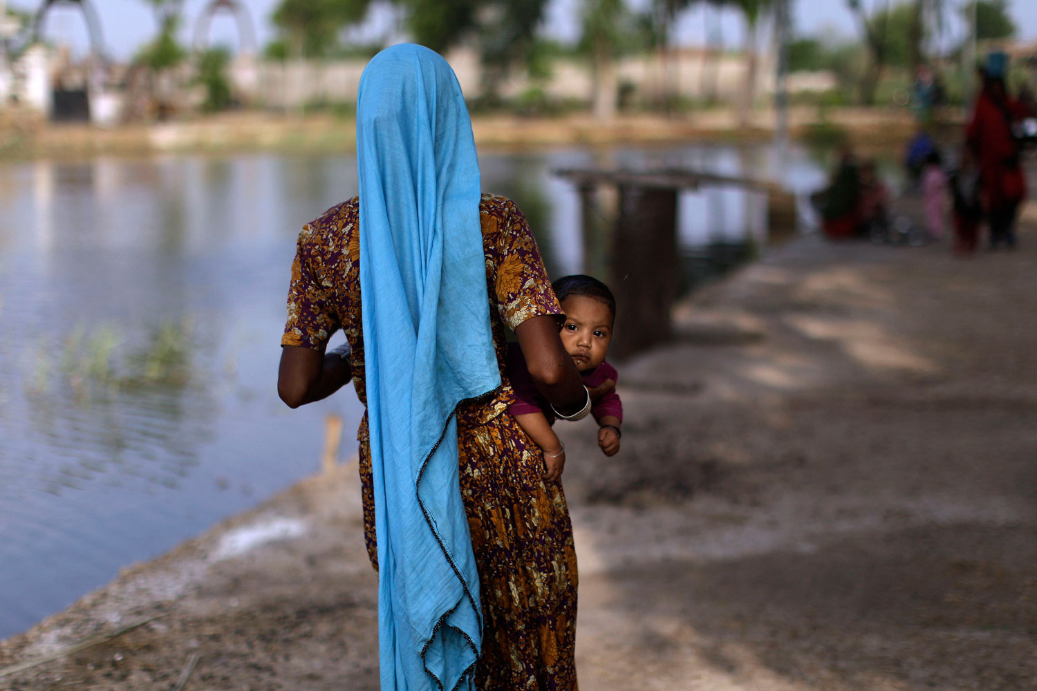 September 22, 2011. A displaced Pakistani child looks on while being held by her mother as they and others take refuge in a college in Tando Muhammad Khan near Hyderabad, Pakistan, after fleeing their flood-hit homes. Many people are still stranded by floods that first hit Pakistan in August following unusually heavy monsoon rains and have affected at least 5.4 million people. 