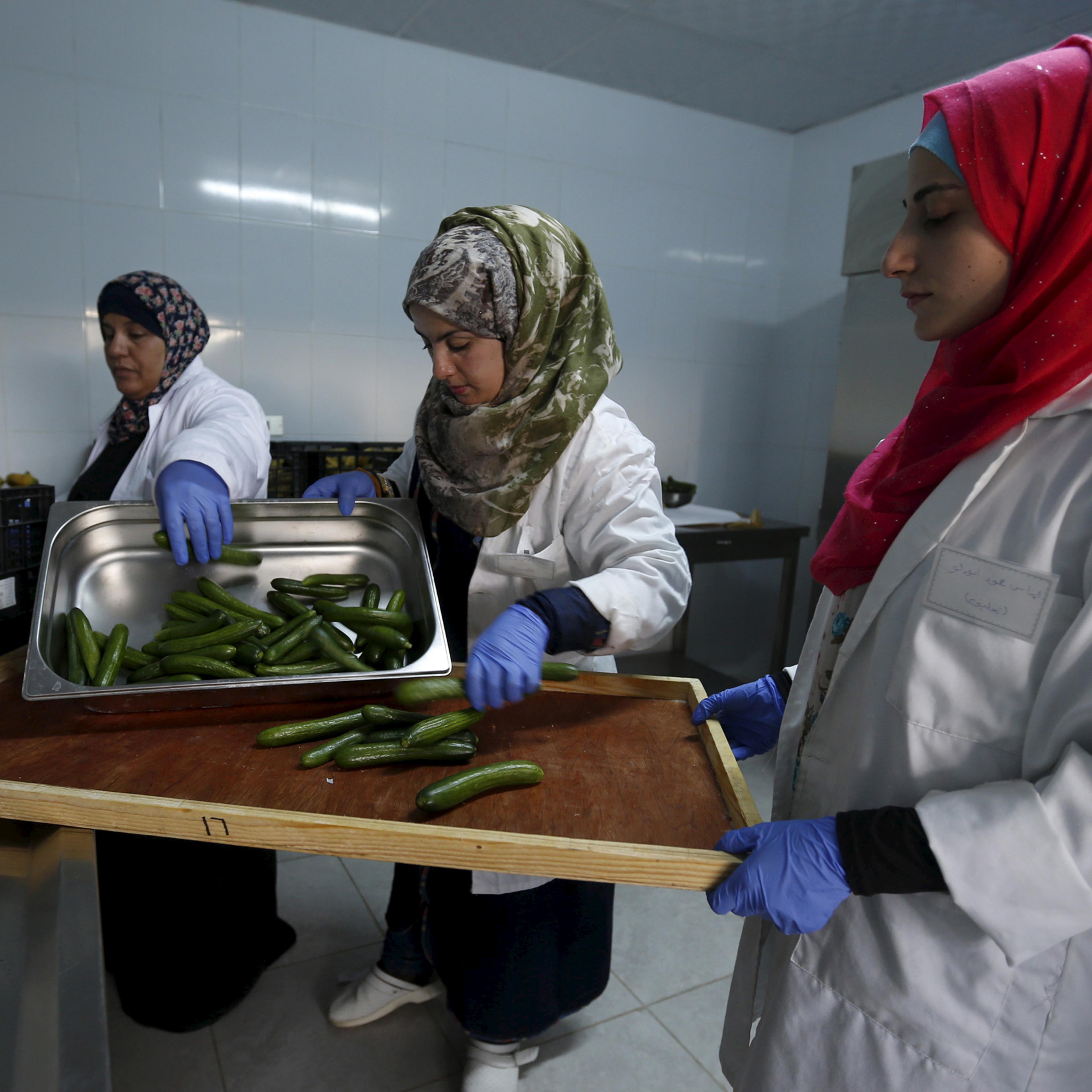 Workers prepare meals for students as part of a World Food Programme (WFP)-run project to provide healthy meals to students and to raise awareness of good eating habits, in the city of Irbid, Jordan, April 26, 2016. REUTERS/ Muhammad Hamed - RTX2BQN2