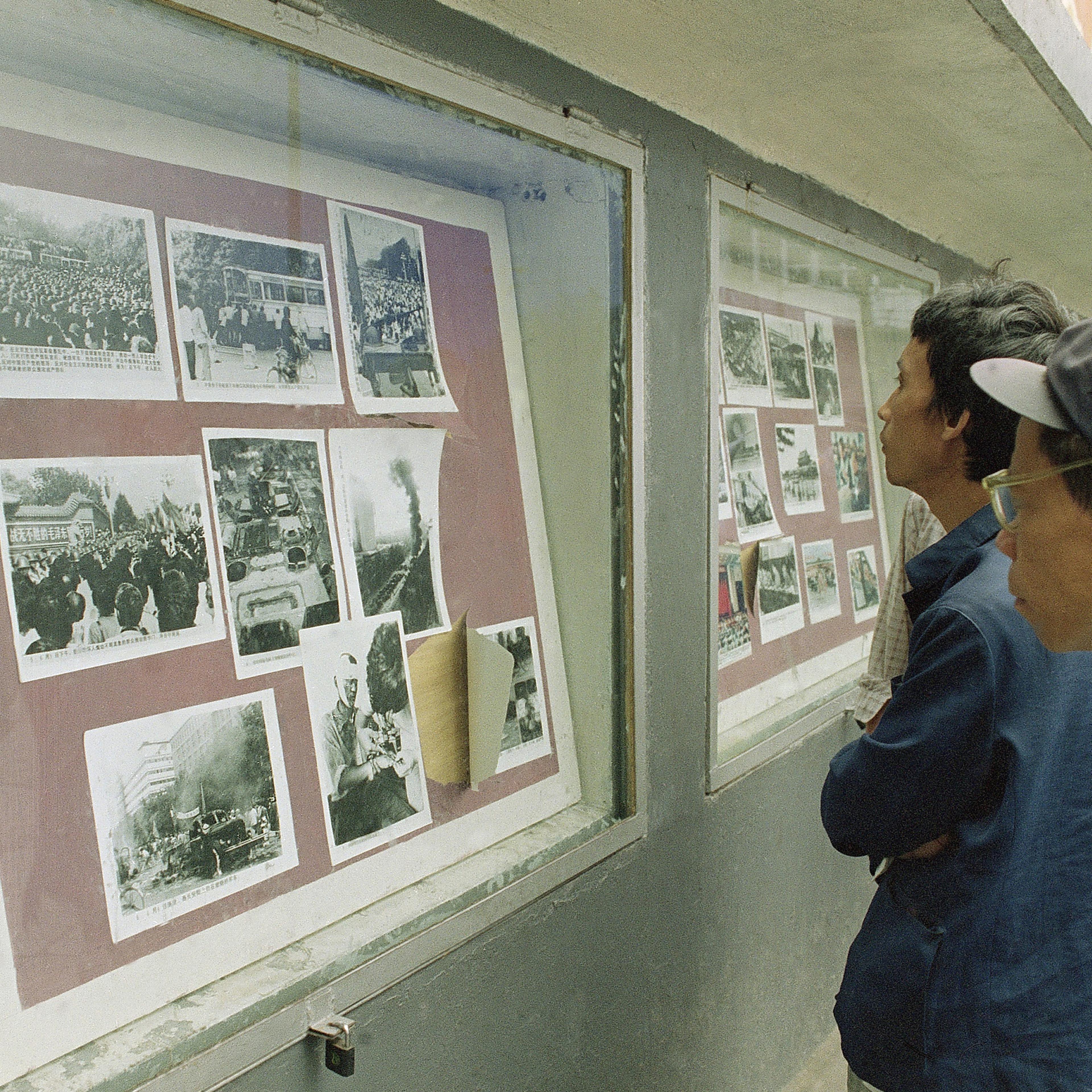 Viewers crowd around an official photo display in Chengdu, Sichuan Province, China Oct. 30, 1989 that depicts violent battles there in June between police and a crowd angered by the Beijing Tiananmen Square killings.
