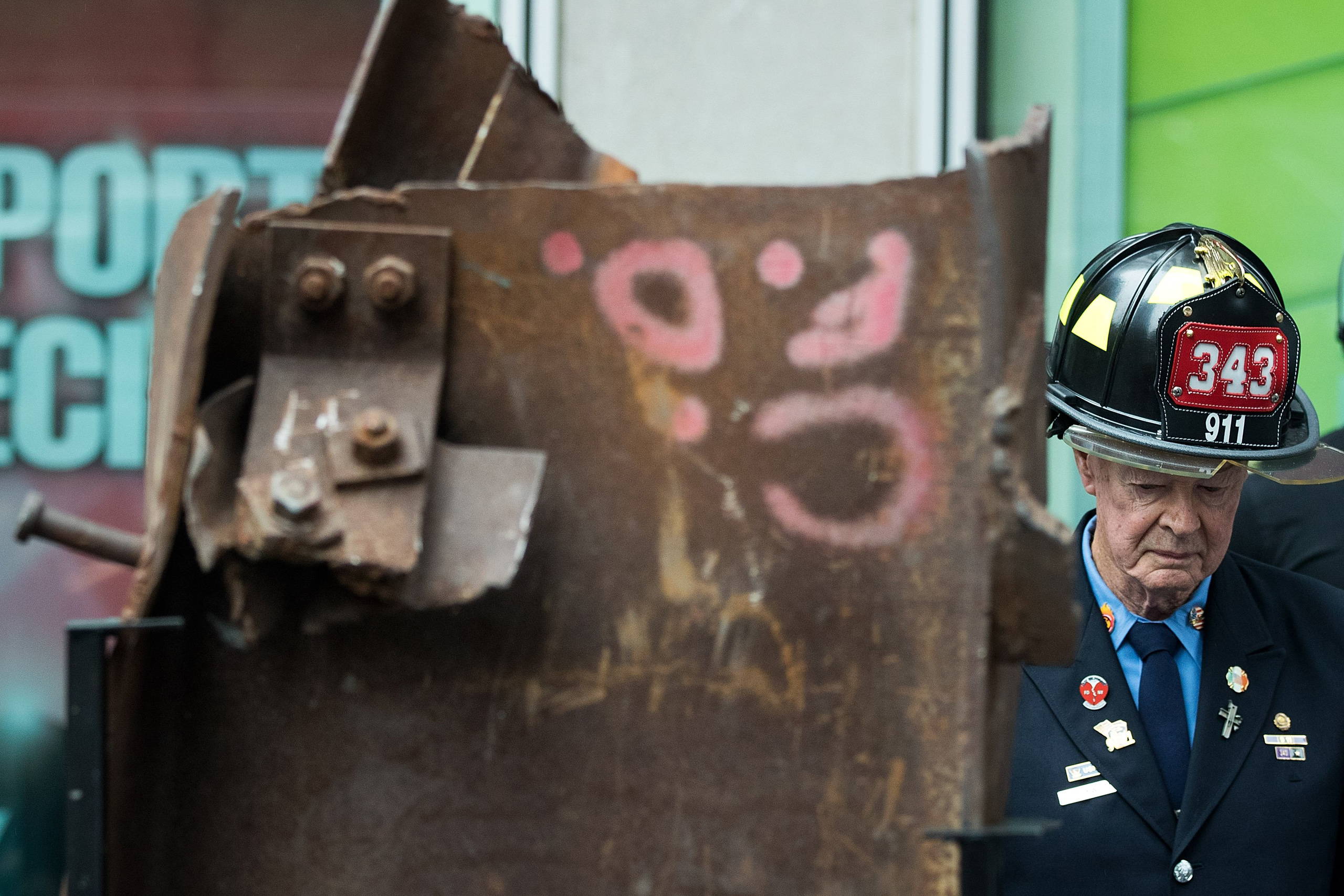 Bob Beckwith, retired firefighter who stood next to President George W. Bush at ground zero, stands next to a piece of steel from the World Trade Center, during a ceremony outside the Fox News studios to mark the beginning of the piece of steel's journey