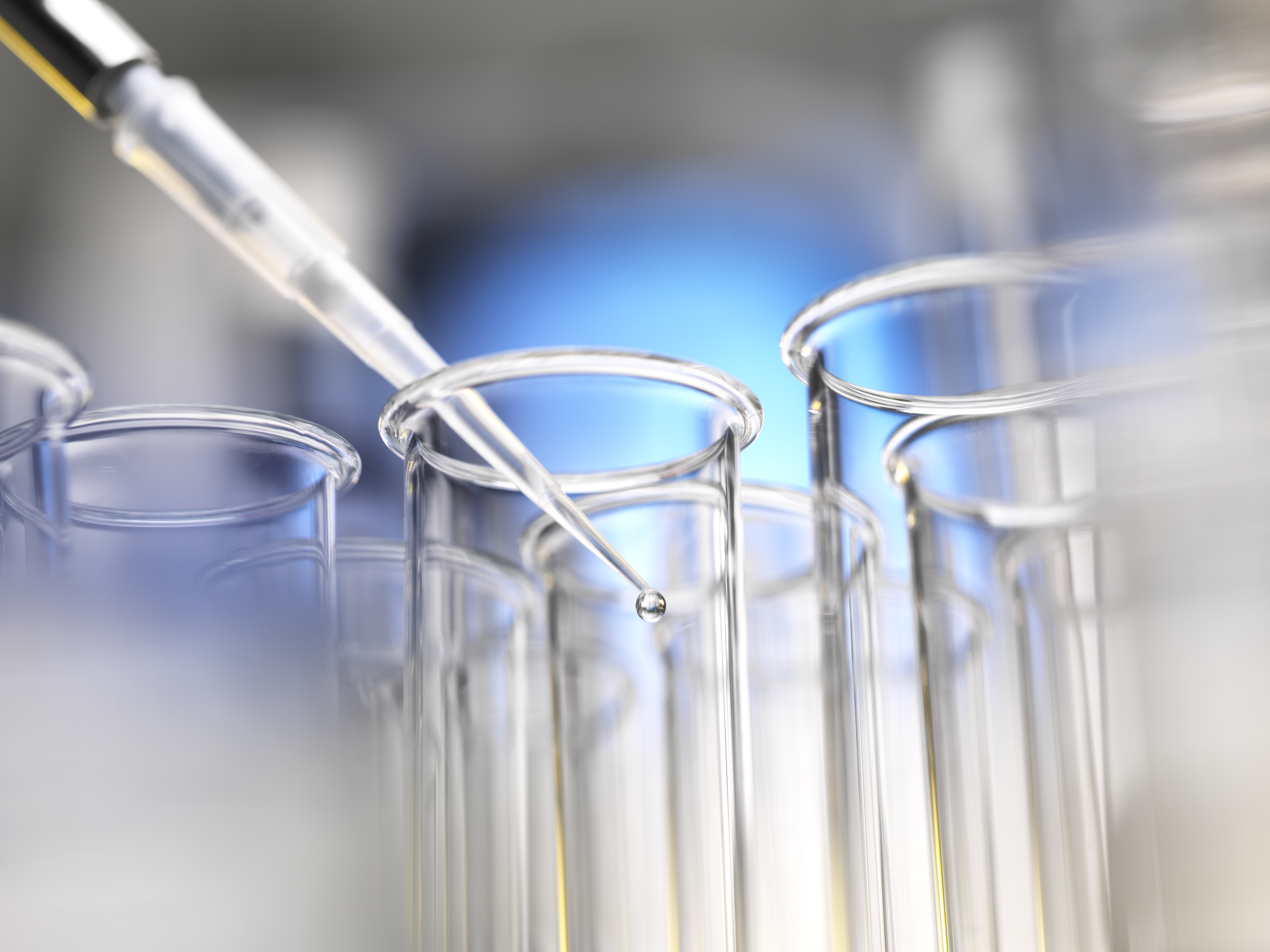 Scientist pipetting a sample into a test tube during a experiment in the laboratory