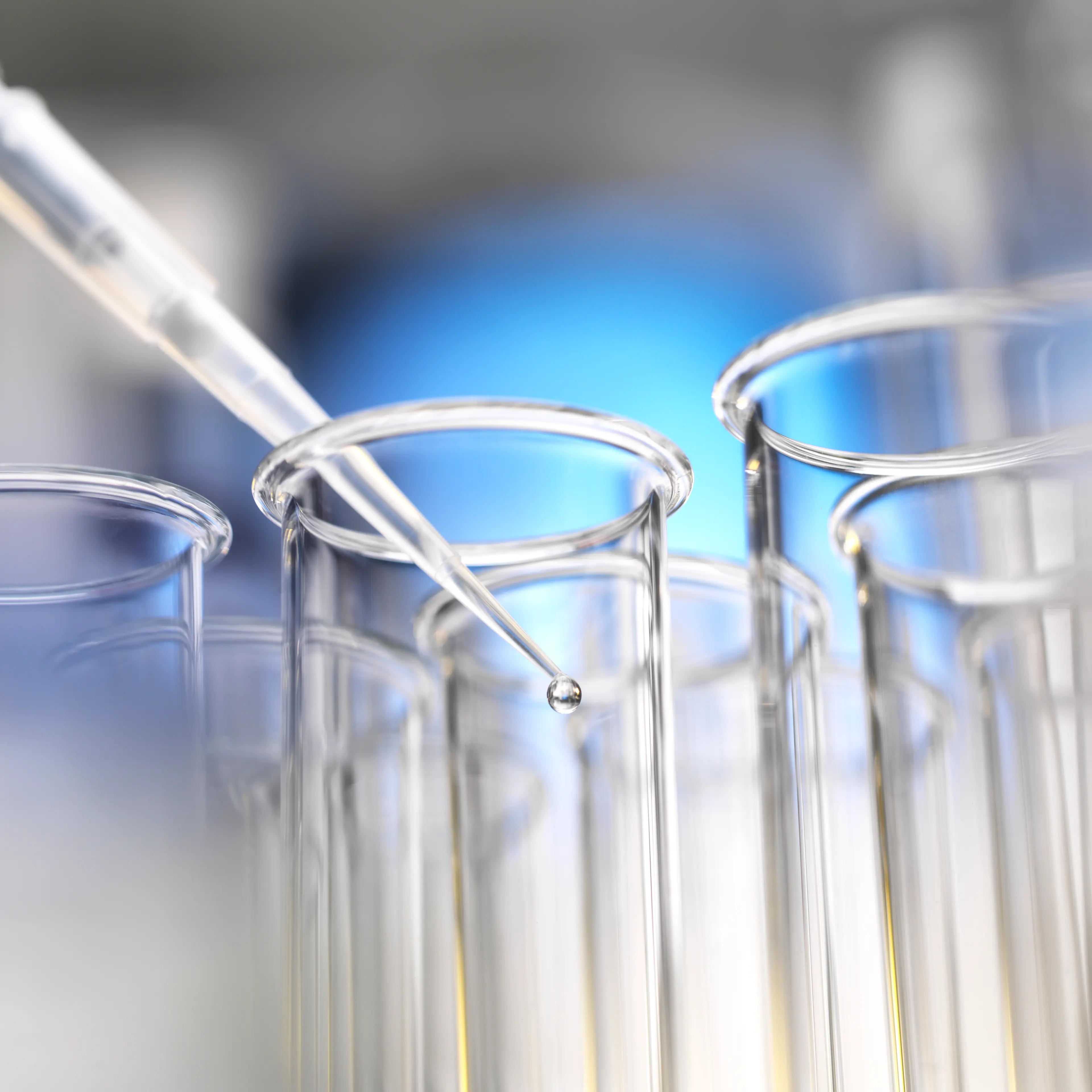 Scientist pipetting a sample into a test tube during a experiment in the laboratory